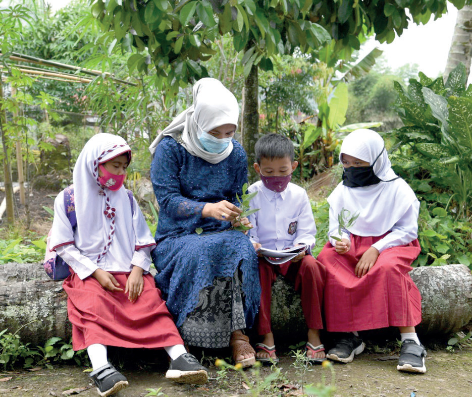 Sejumlah siswa SD Negeri di Jambi sedang belajar mengenal tanam-tanaman bersama seorang guru dalam belajar di luar ruangan.