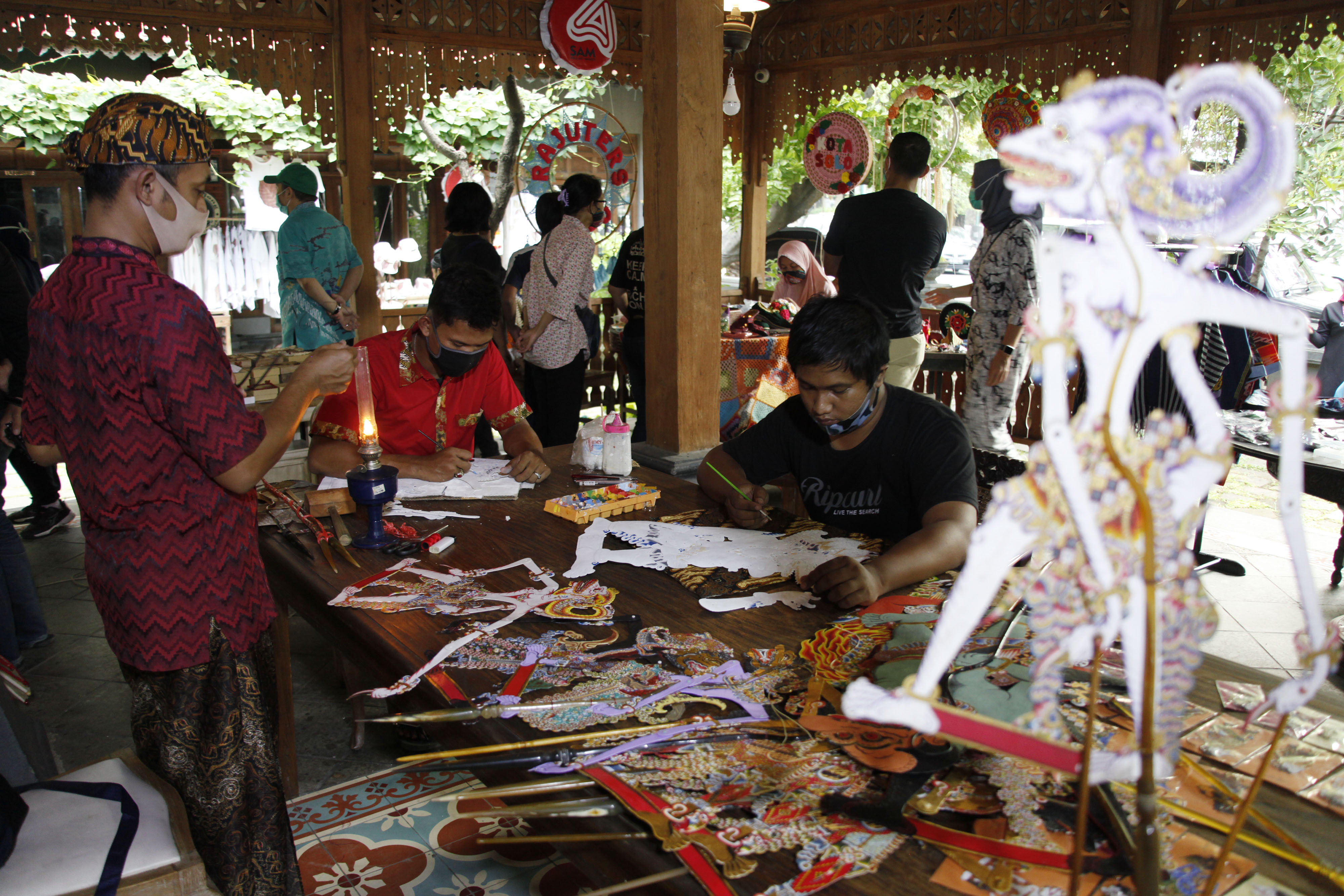Perajin memperlihatkan cara membuat wayang kulit di Solo Art Market