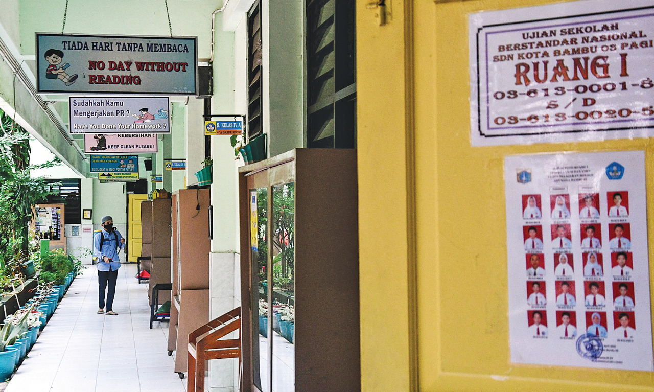 Petugas kebersihan sekolah menyemprotkan disinfektan di lingkungan SDN 03 Kota Bambu, Tanah Abang, Jakarta, kemarin. 