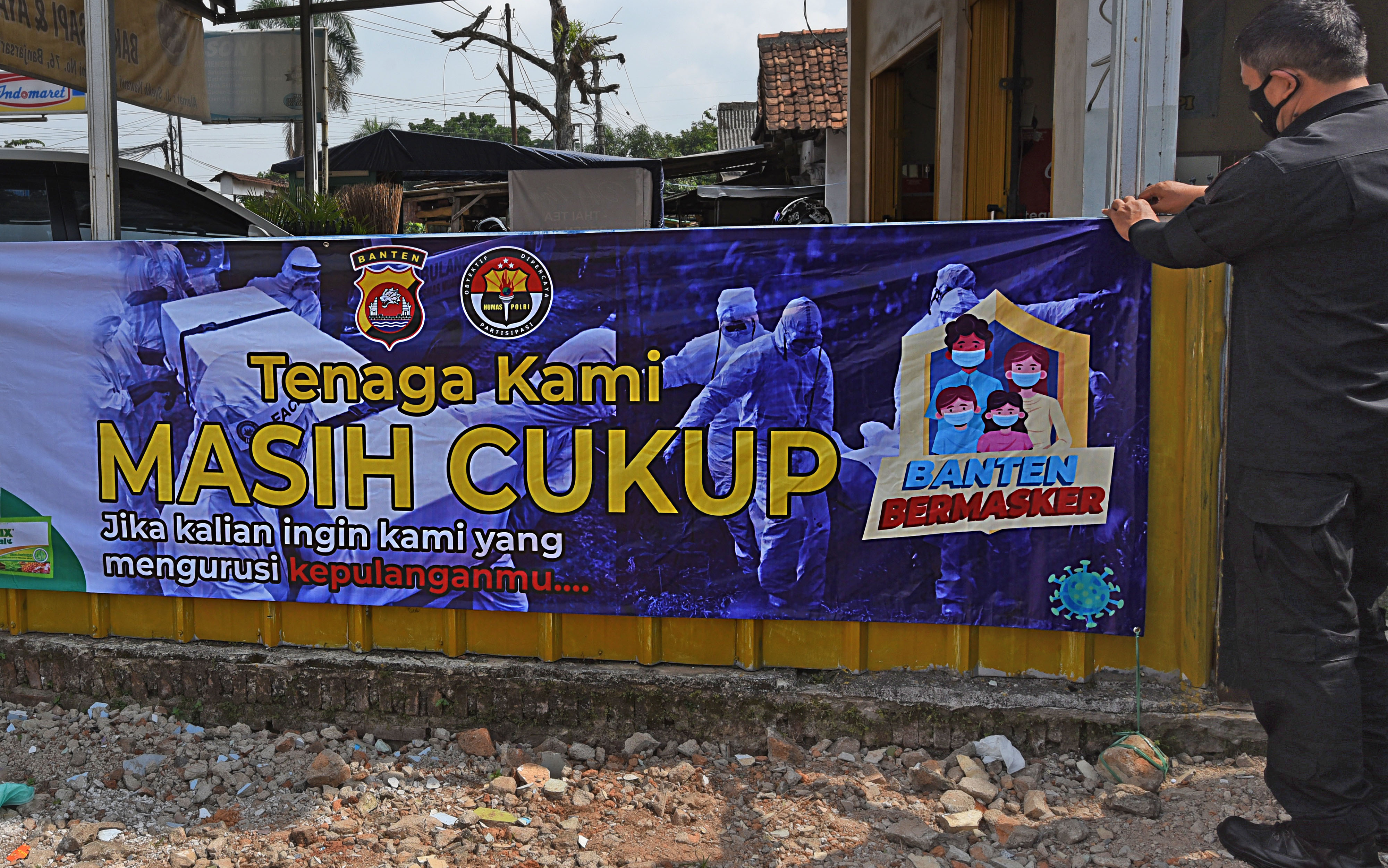 Personel Polda Banten memasang spanduk ajakan mengenakan masker di Jalan Syekh Nawawi, Serang, Banten, beberapa waktu lalu.