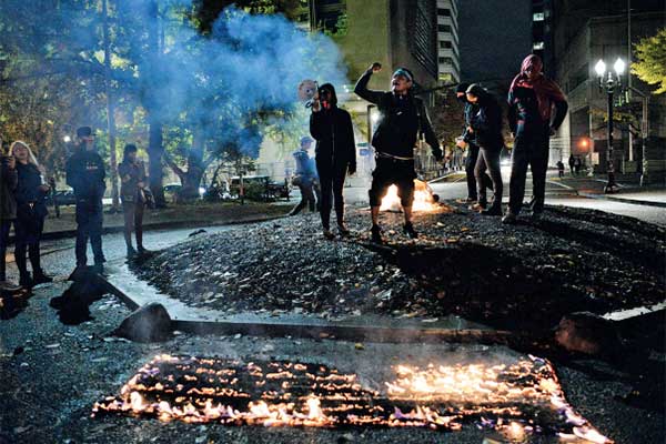 Pengunjuk rasa membakar bendera Amerika Serikat di luar Gedung Pengadilan Mark O Hatfi eld di Portland, Oregon, AS