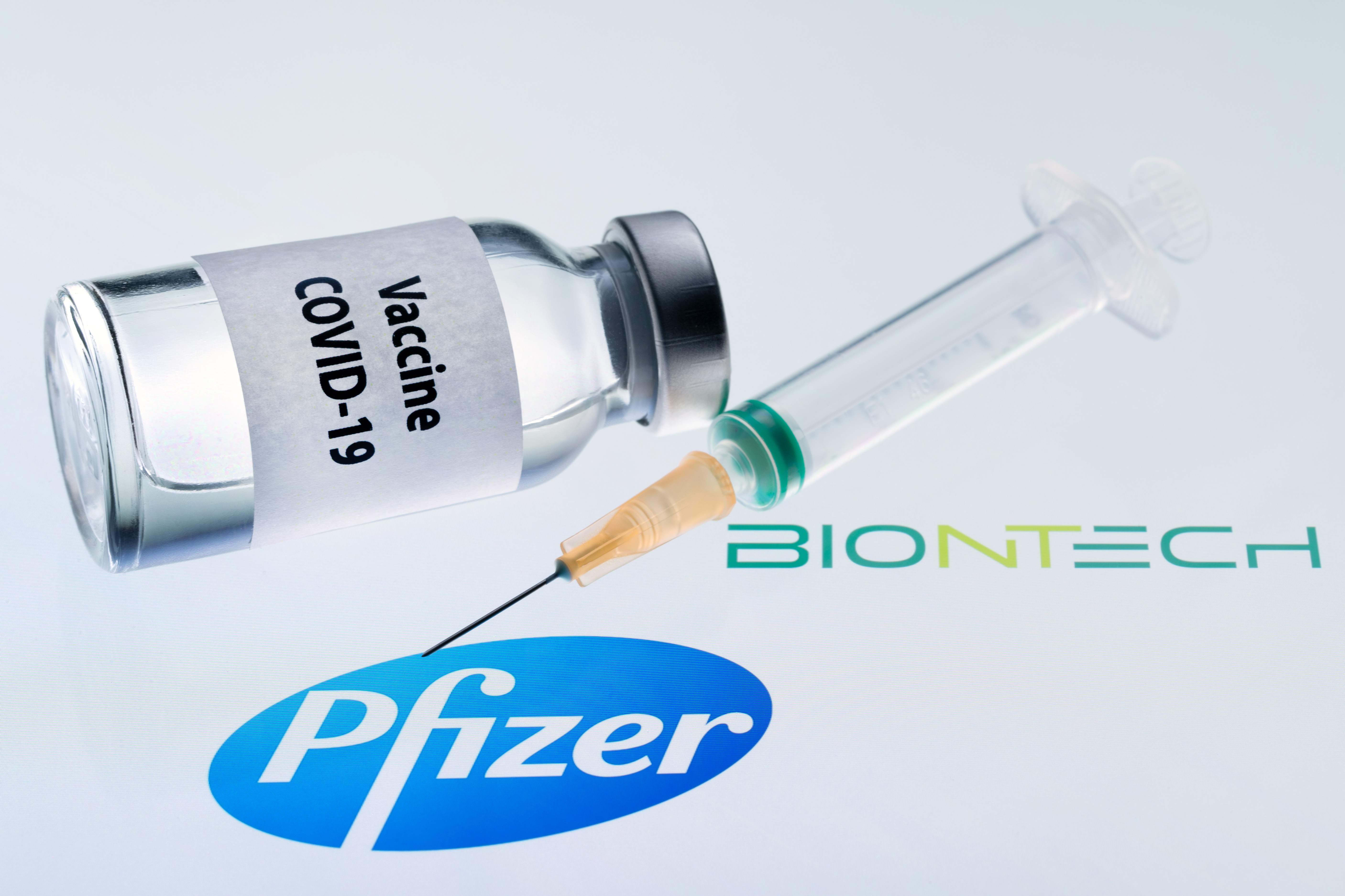 Foto ilustrasi yang menampilkan tabung bertuliskan vaksin covid-19 bersama logo Pfizer dan Biontech.