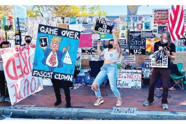Pendukung calon presiden AS, Joe Biden, merayakan hasil perhitungan sementara  di alun-alun dekat Gedung Putih, AS, Jumat (6/11).
