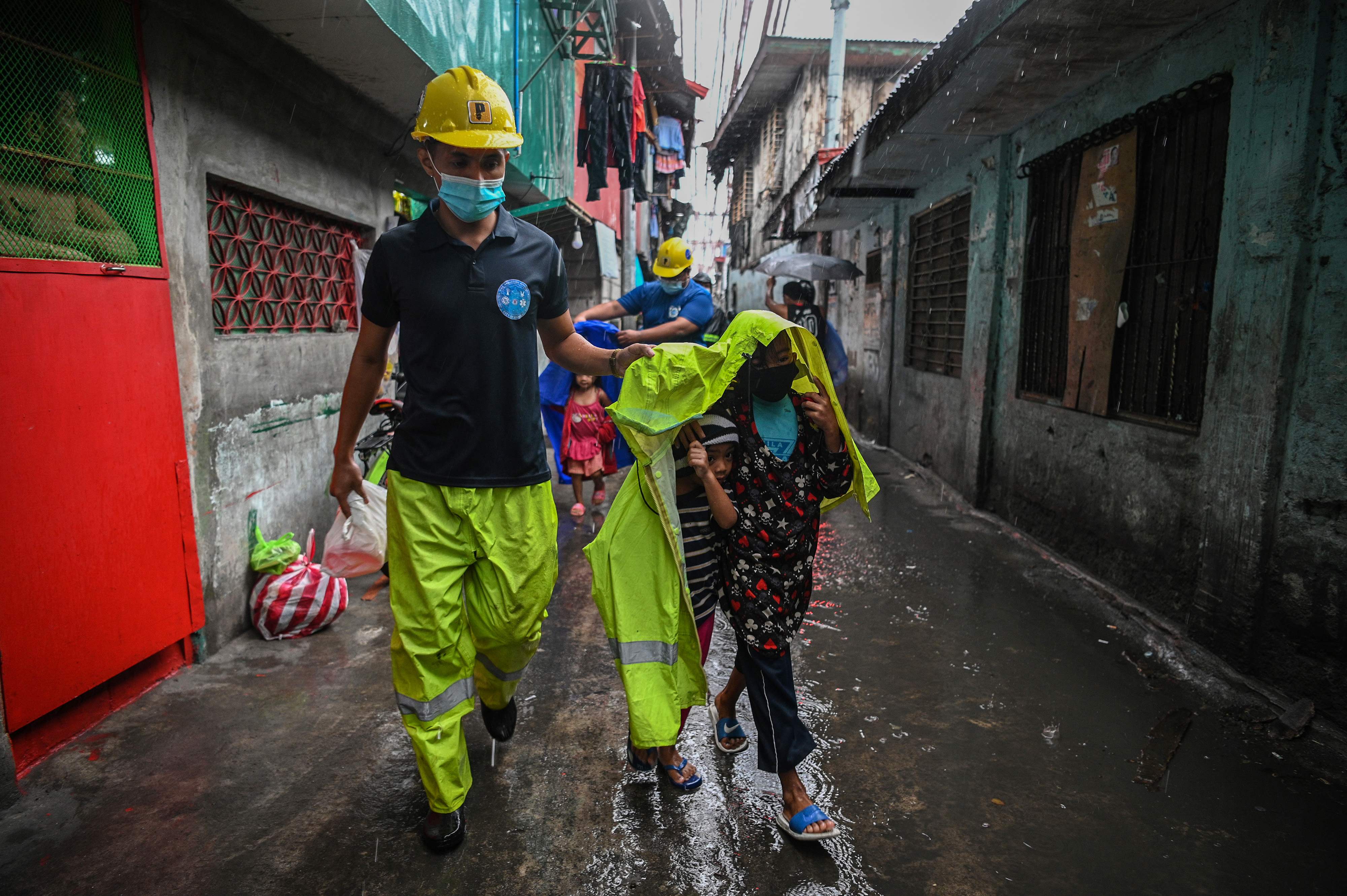 Petugas mengawal anak-anak yang dievakuasi di Manila, Filipina, seiring mendekatnya Topan Super Goni.