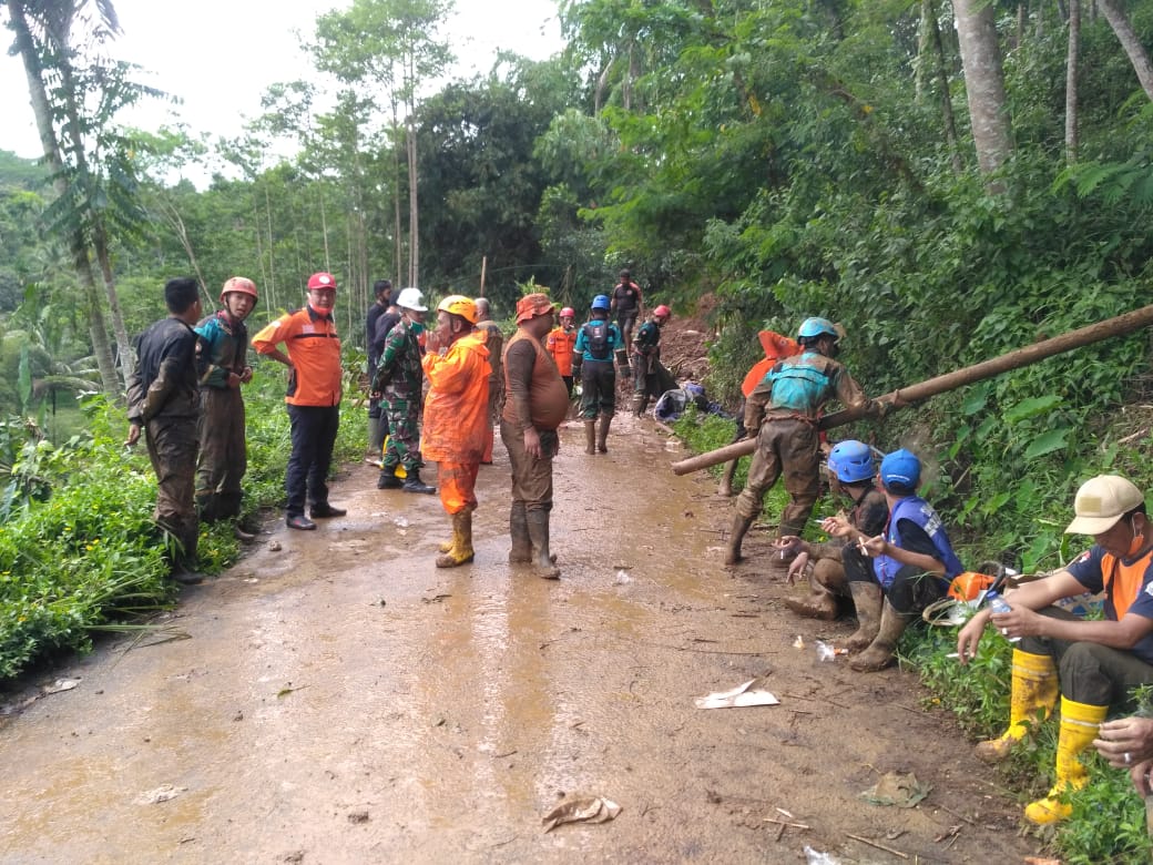 Petugas gabungan membersihkan longsoran yang menutup jalan di Tasikmalaya, Kamis (19/11/2020).