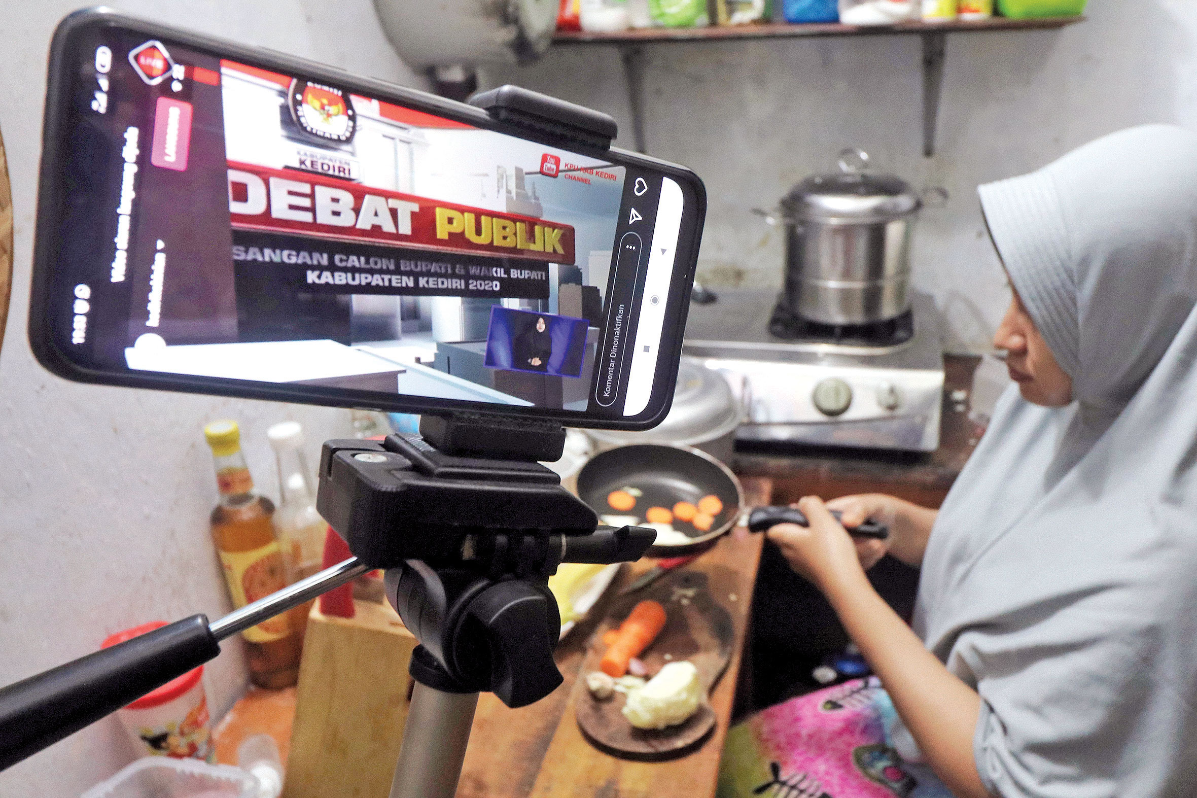 Warga sambil memasak menyaksikan debat publik calon tunggal Bupati Kediri Haninditho Himawan Pramono yang disiarkan secara live streaming  