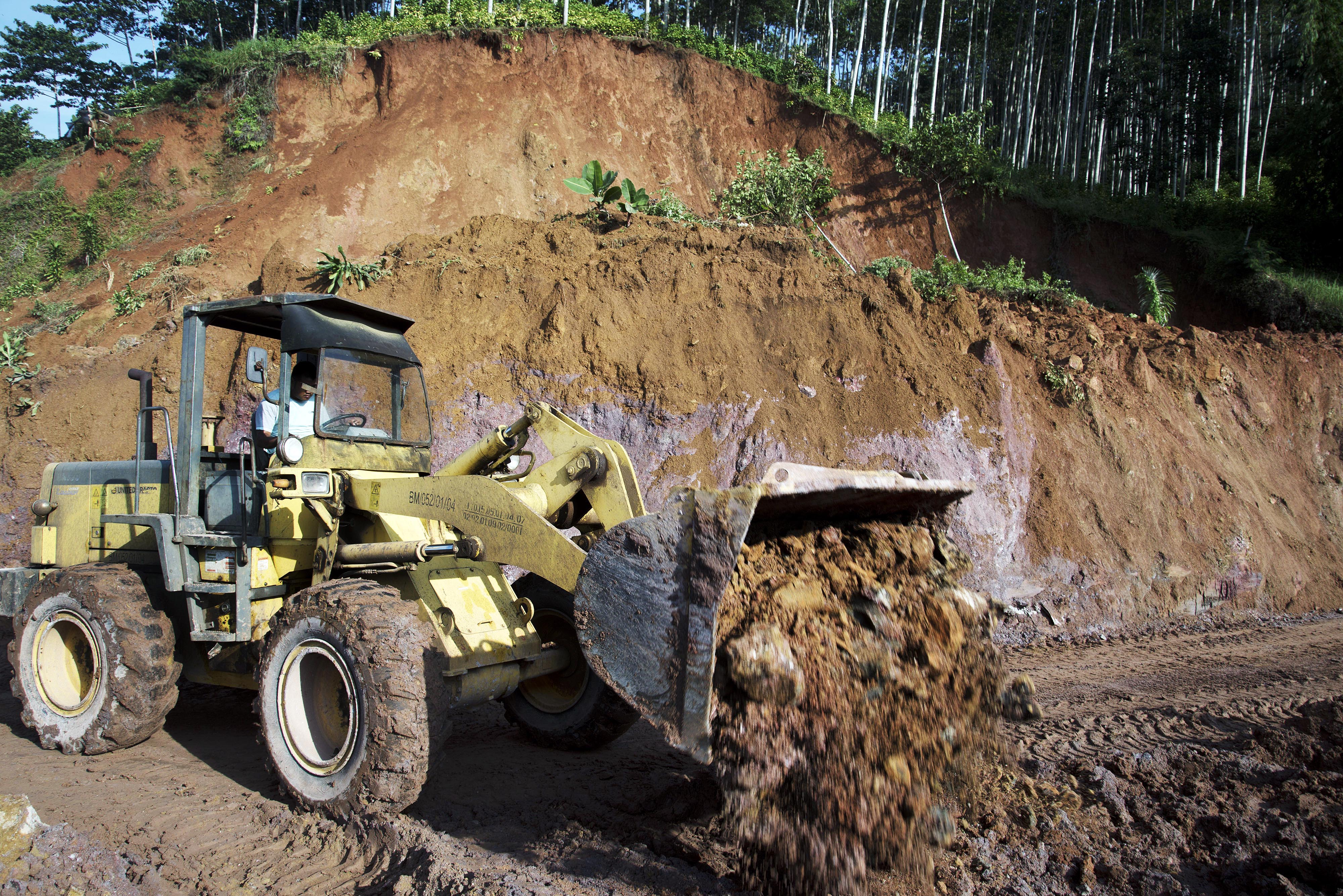Alat berat digunakan untuk membersihkan jalan dari material longsor di jalan utama Cianjur-Sukanagara, Sukanagara, Cianjur, Jawa Barat.