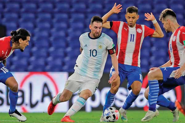 Pemain Argentina Lionel Messi (tengah) membawa bola dengan dikawal ketat tiga pemain Paraguay 