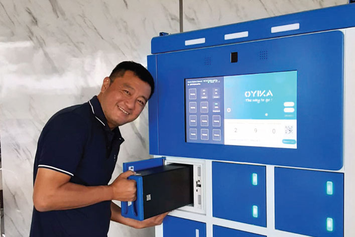 BATERAI MOTOR LISTRIK: Presiden Direktur PT Oyika Powered Solutions Larry Lim memperagakan penukaran baterai sepeda motor listrik  