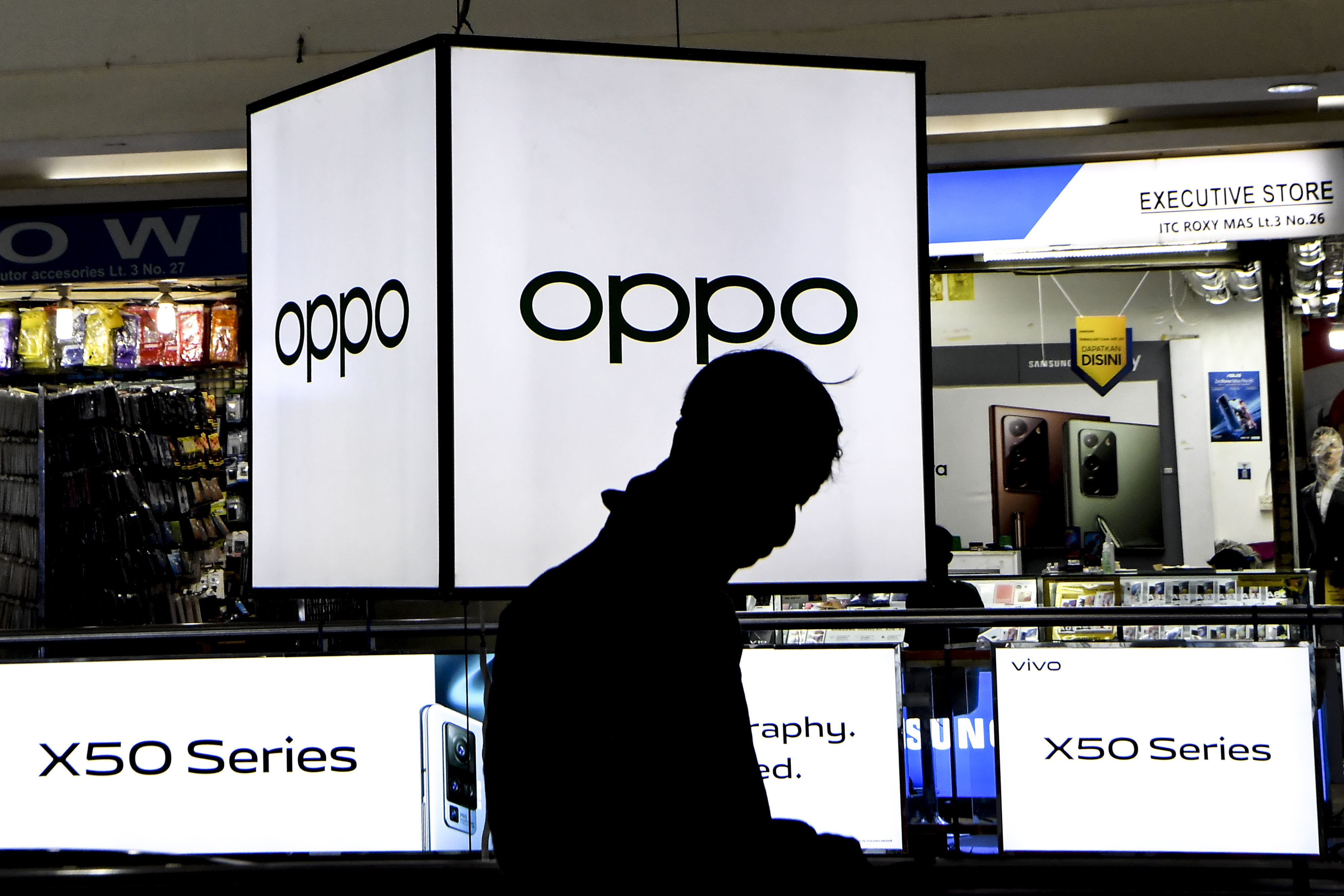  Seorang pengunjung melintas di depan papan iklan penjualan ponsel di Jakarta, Selasa (15/9/2020)