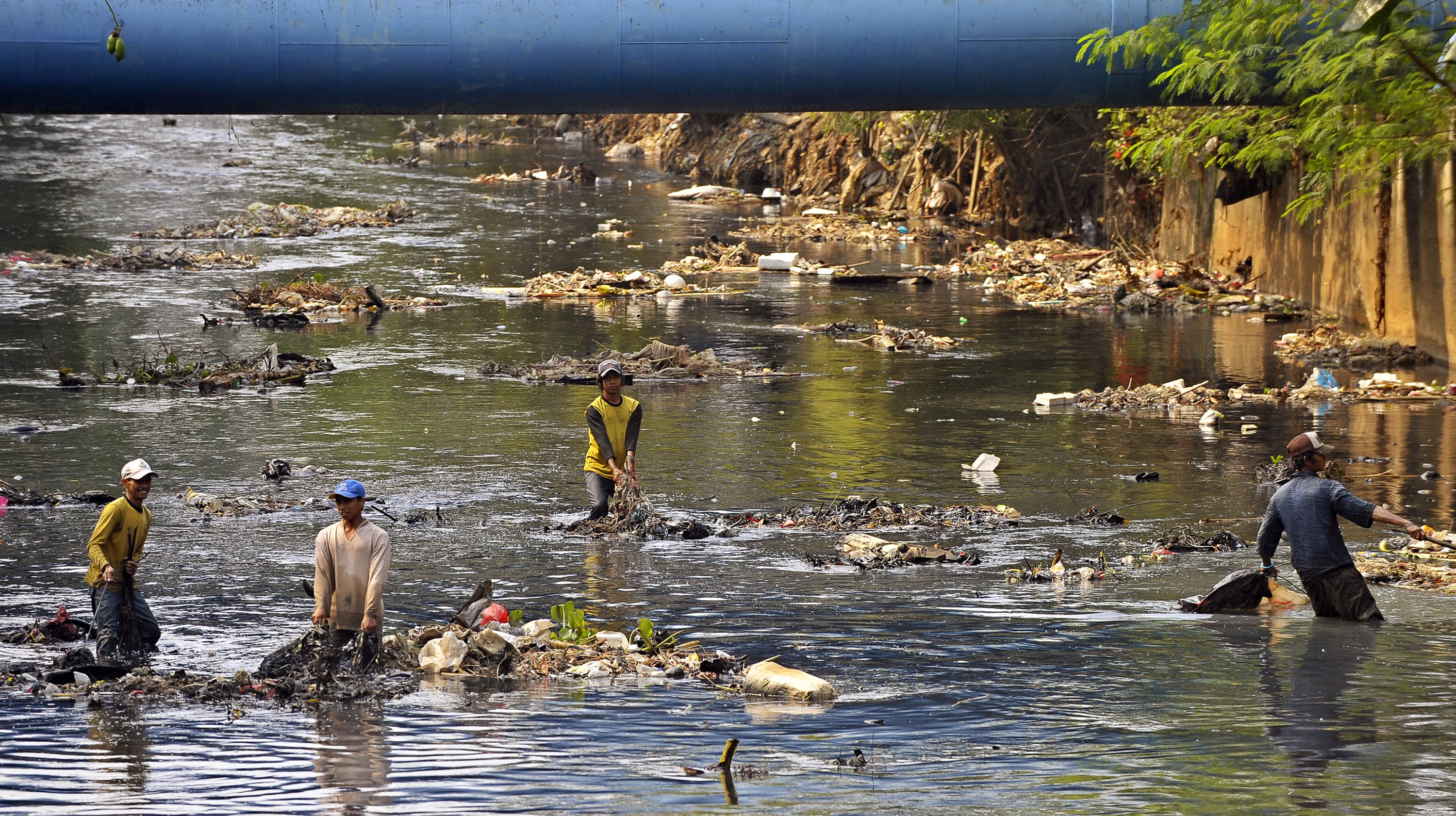 Ilustrasi--Pekerja mengangkat sampah dari dasar sungai di kawasan Kalimalang, Jakarta Timur.