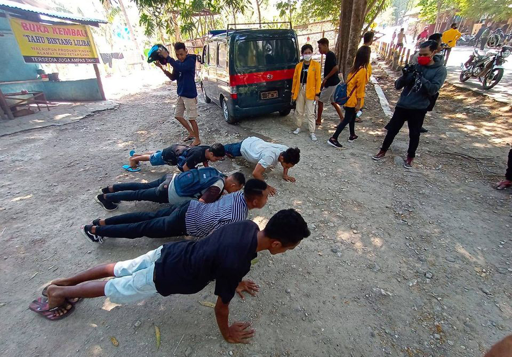 Beberapa orang dihukum push up setelah terjaring operasi penertiban masker di Kelurahan Liliba, Kupang, Nusa Tenggara Timur, Kamis (19/11).