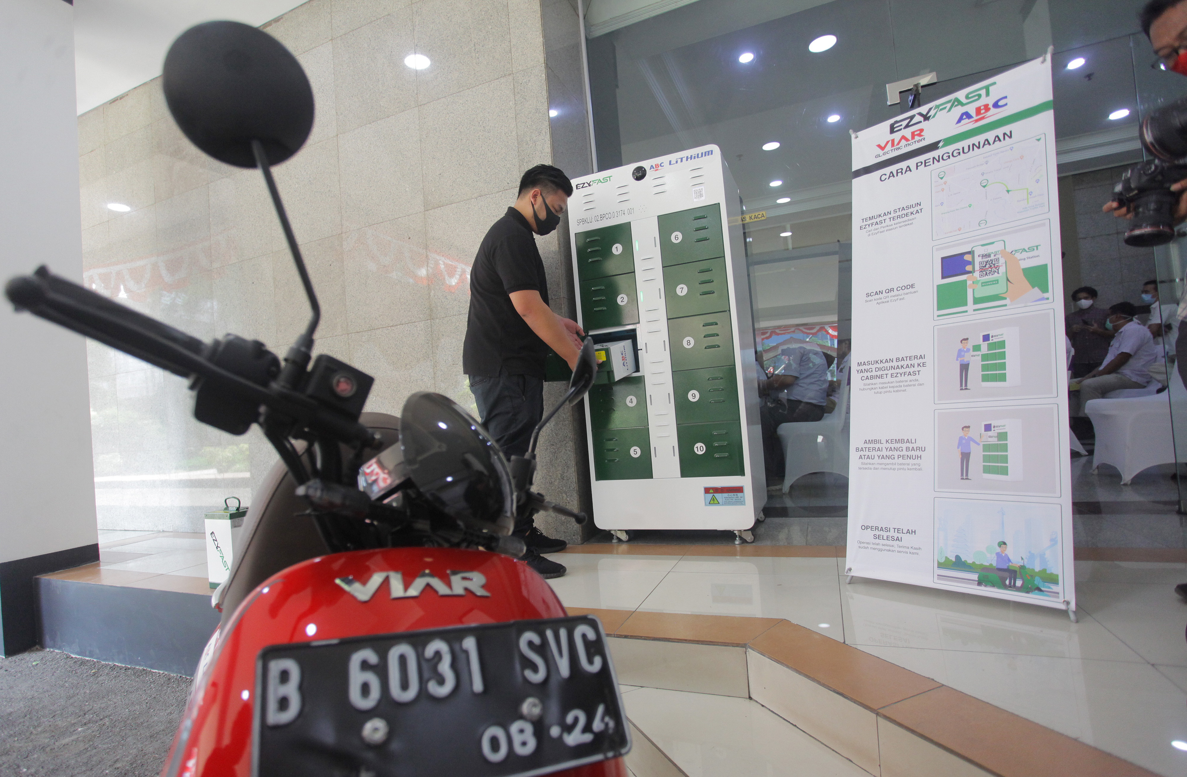 Petugas uji coba penggantian baterai sepeda motor listrik saat melakukan uji coba SPBKLU, di Jakarta, Senin (31/8)