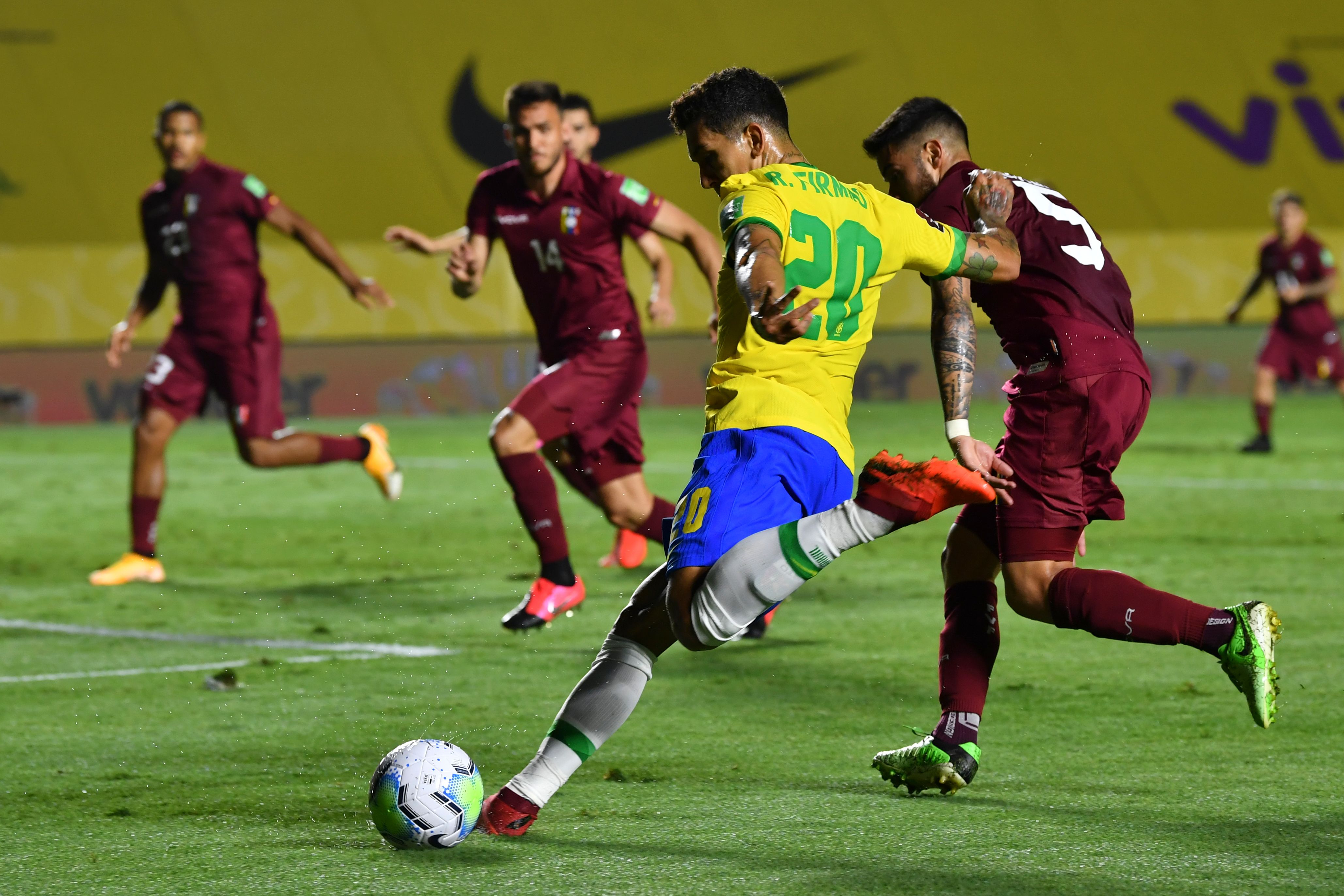 Gelandang serang Brasil Roberto Firmino (tengah) berusaha menendang bola dengan dibayang-bayangi pemain Venezuela Junior Moreno.