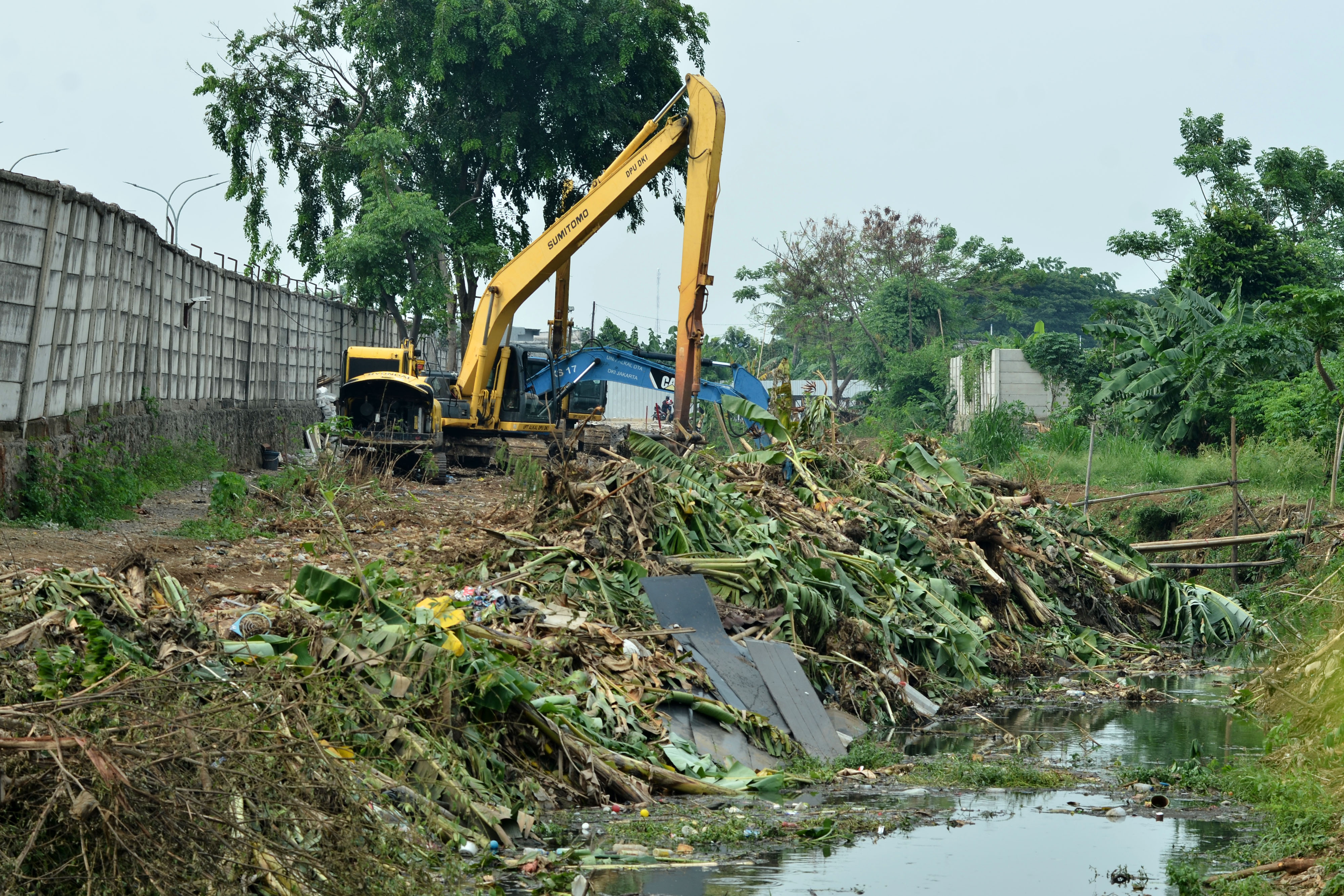 Petugas Sudin DSA Jakarta Timur melakukan pengerukan lumpur menggunakan alat berat di Kali Tambun Rengas, Cakung.