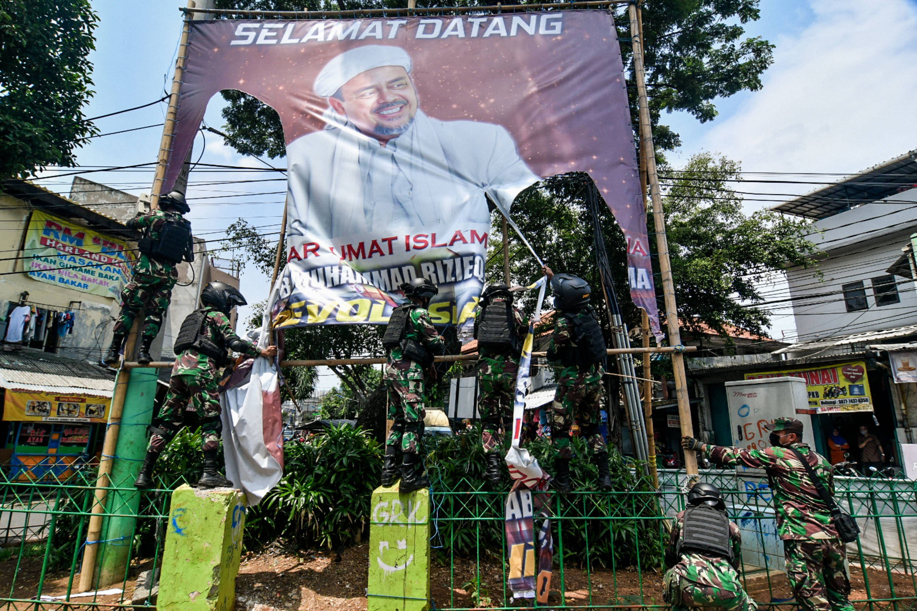 Sejumlah anggota TNI mencopot baliho bergambar wajah pimpinan FPI Rizieq Shihab di kawasan Tanah Abang, Jakarta.