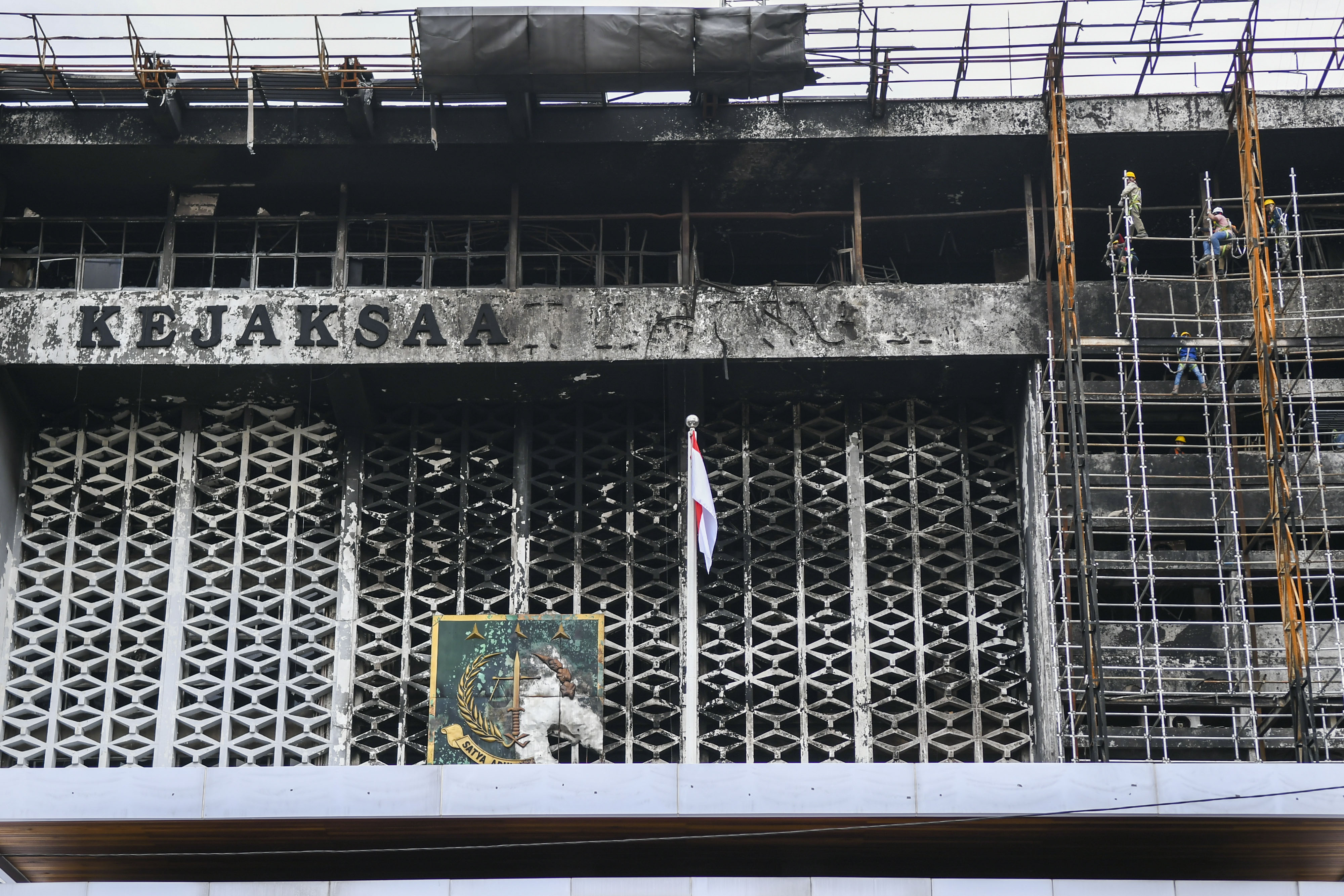 Pekerja memasang steger untuk merenovasi gedung Kejaksaan Agung yang terbakar.