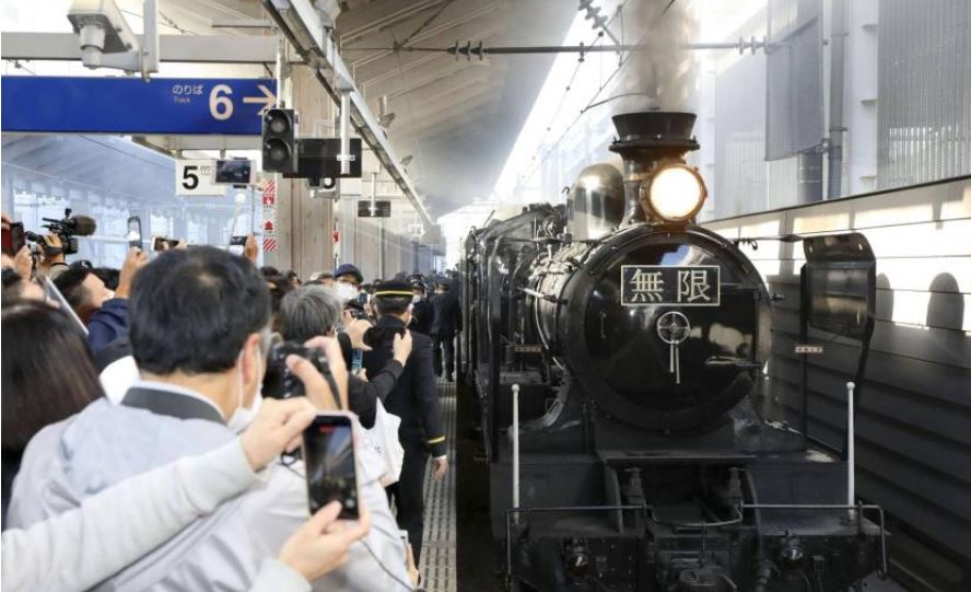 Warga mengambil foto kereta ala film serial manga dan anime populer Demon Slayer di Stasiun Kumamoto, Jepang, Minggu (1/11). 