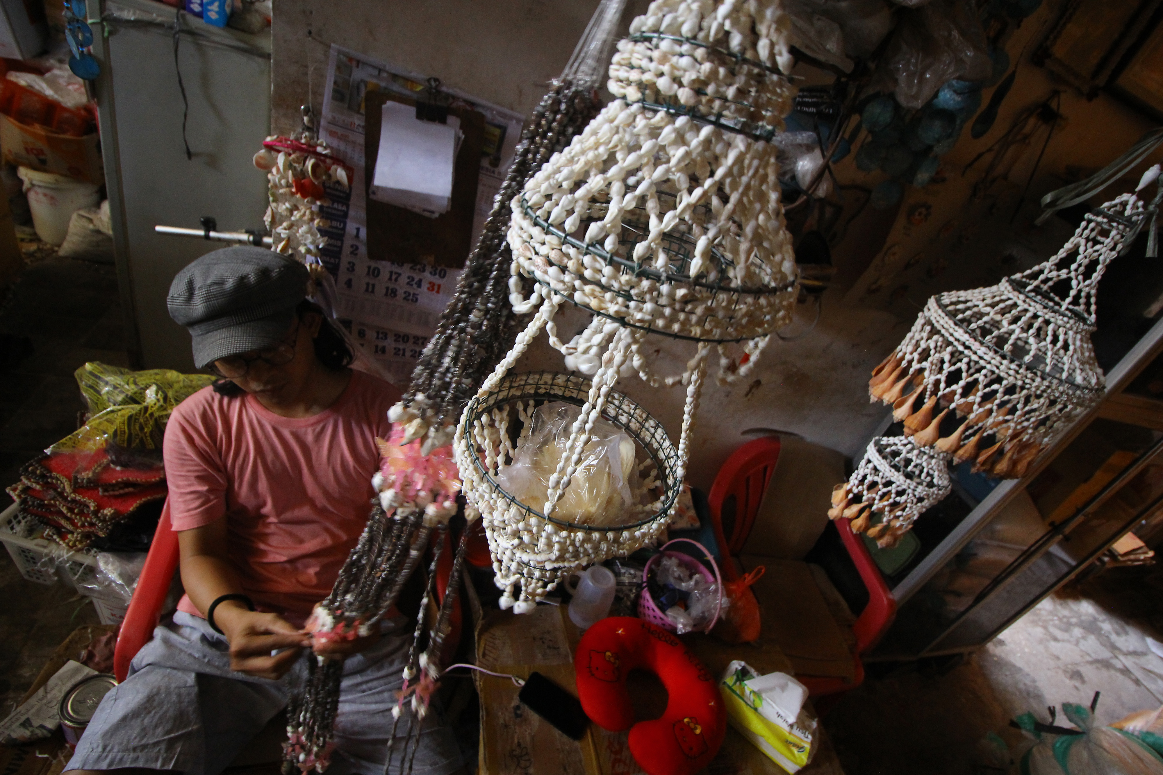 Seorang perajin tengah membuat kerajinan berbahan dasar kerang 