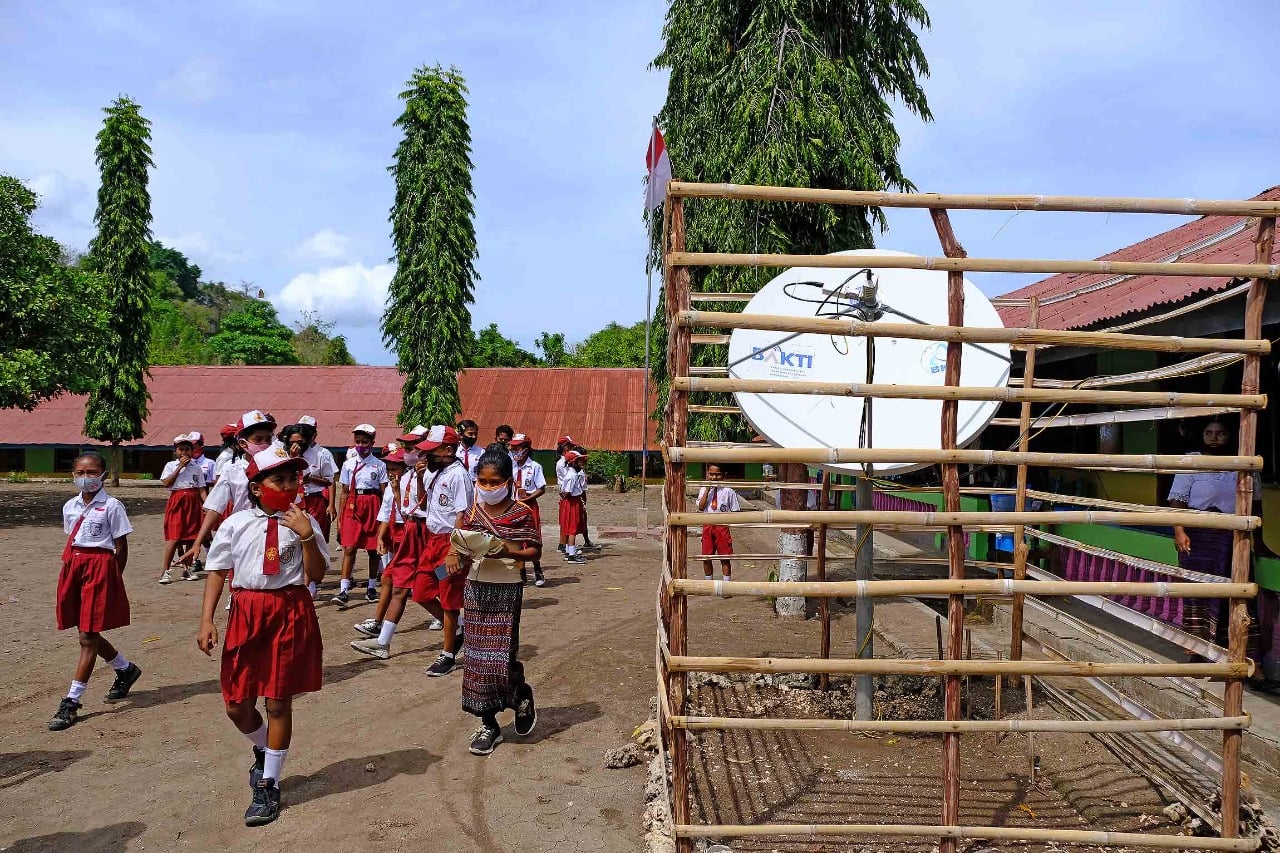Pelajar melintas di samping satelit bantuan Bakti Kominfo di SD Inpres Lewokoli, Desa Aran sina, tanjung bunga, Flores Timur, NTT.