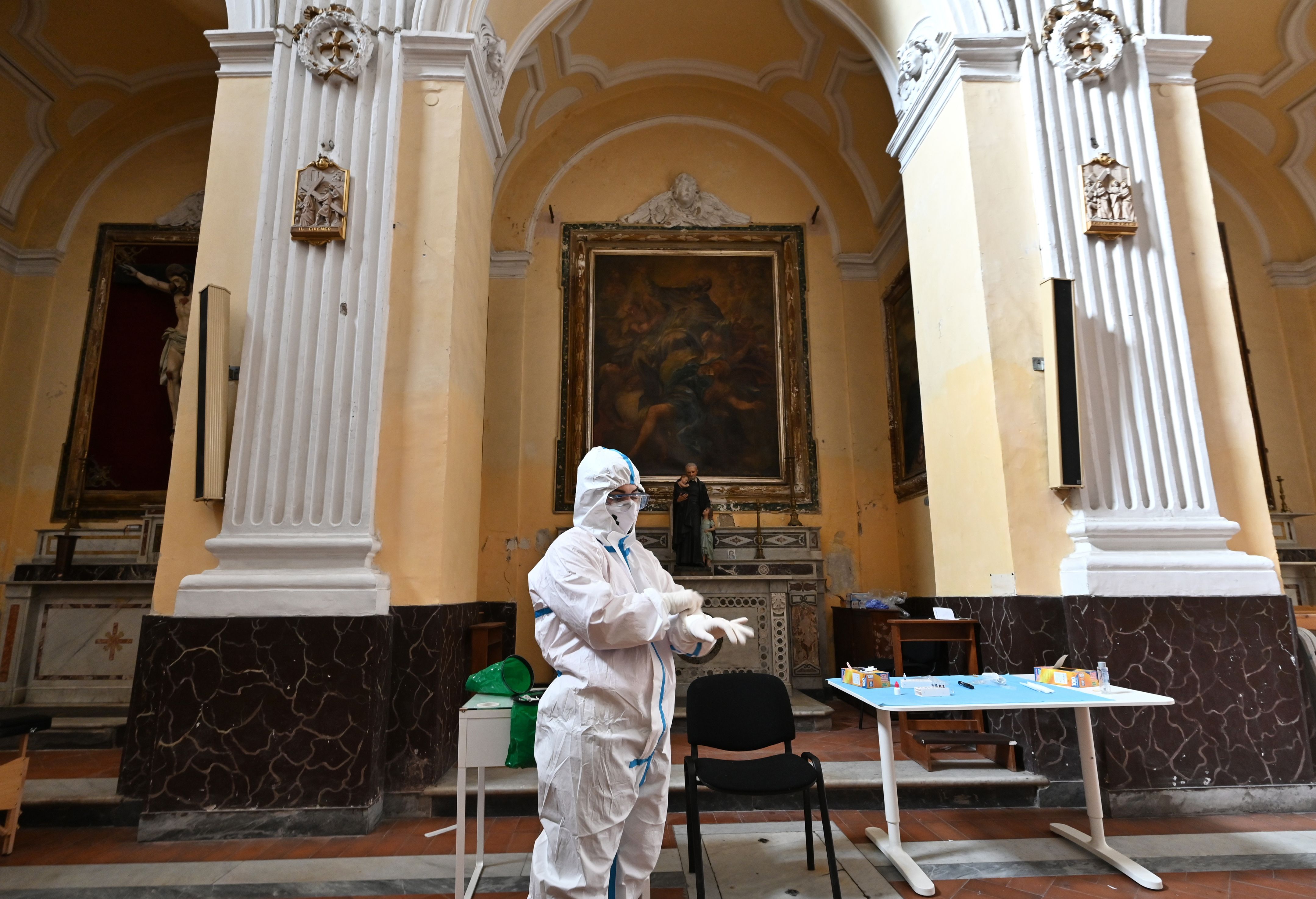 Petugas medis mengenakan APD bersiap melakukan tes antigen terhadap relawan di Naples, Italia.