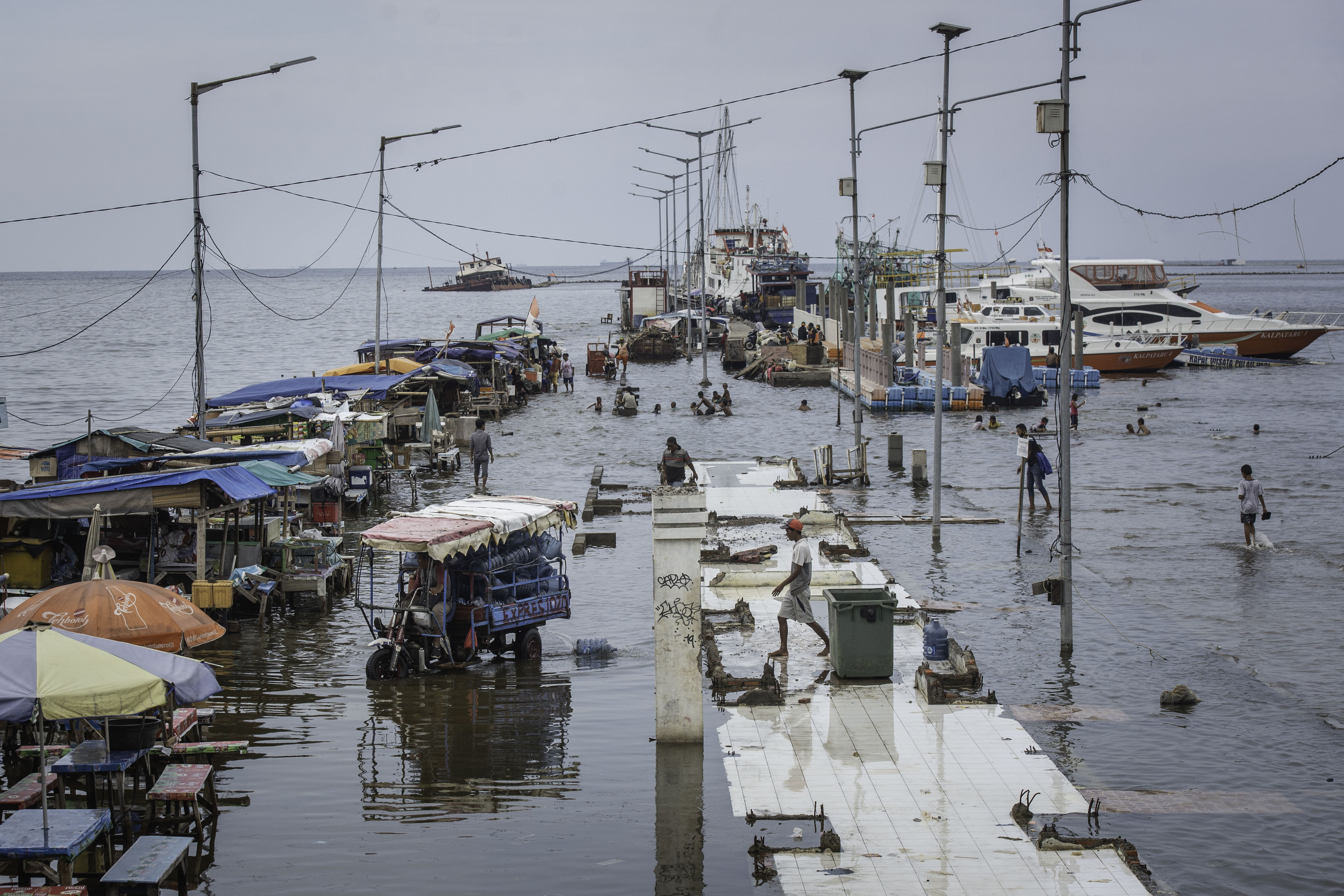 Warga beraktivitas saat banjir rob di Pelabuhan Kali Adem, Muara Angke, Jakarta, Rabu (21/10/2020). 