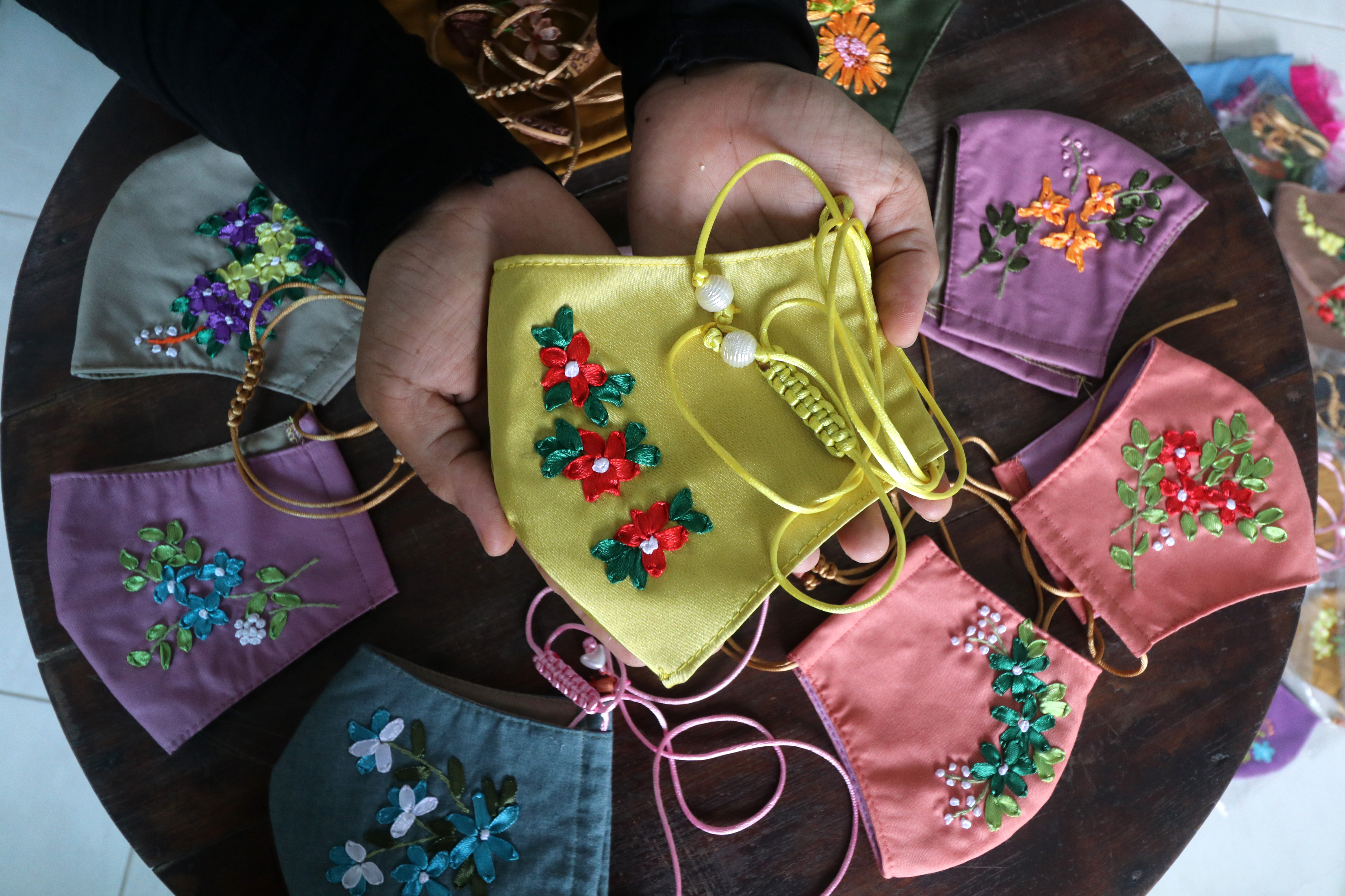  Perajin memperlihatkan masker yang dihiasi sulam pita di Kelurahan Banjarmlati, Kota Kediri, Jawa Timur, Selasa (10/11).