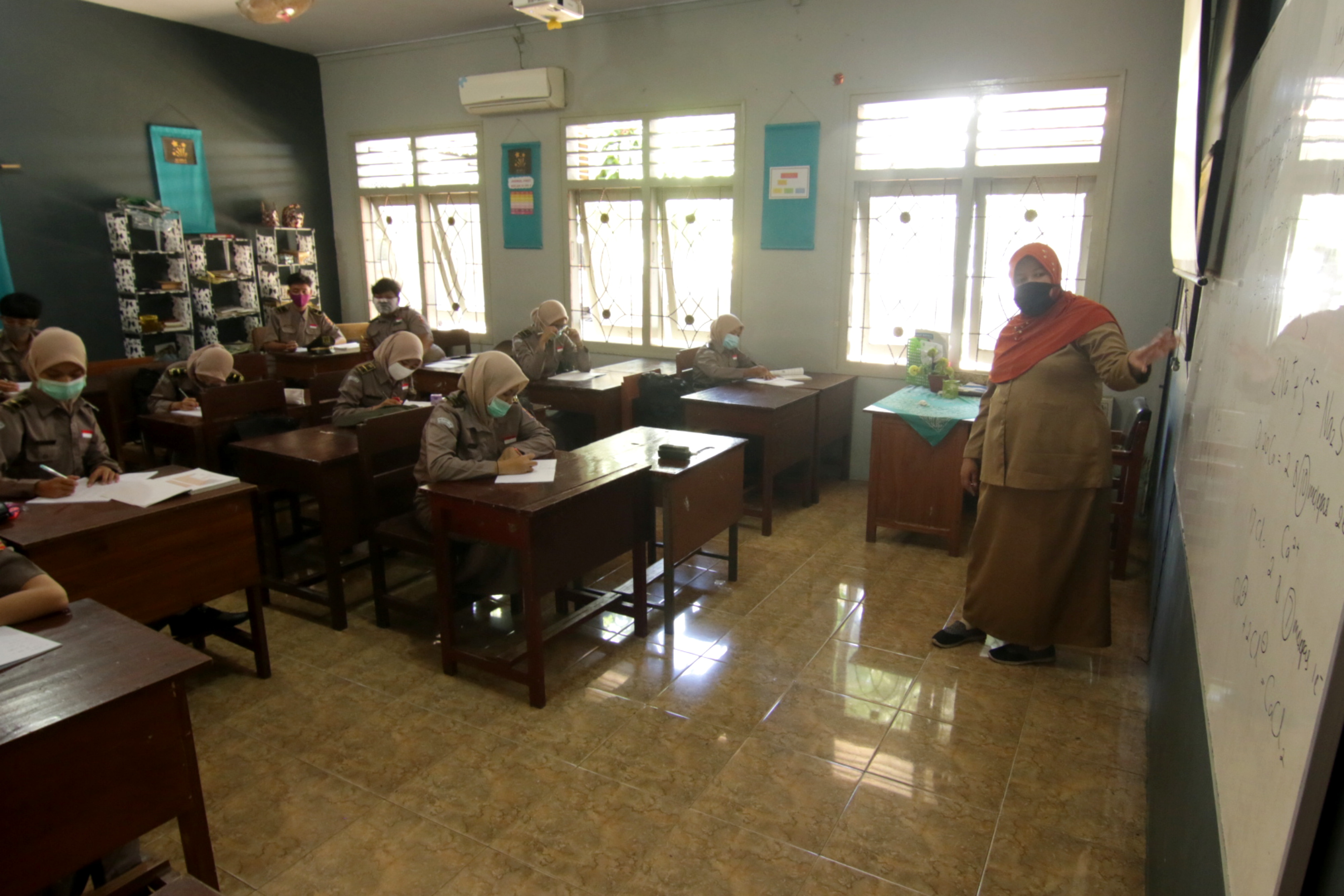 Guru dan murid menggunakan masker pada uji coba sekolah tatap muka di SMA Taruna Bangsa Banyuwangi, Jawa Timur, Senin (16/11/2020)