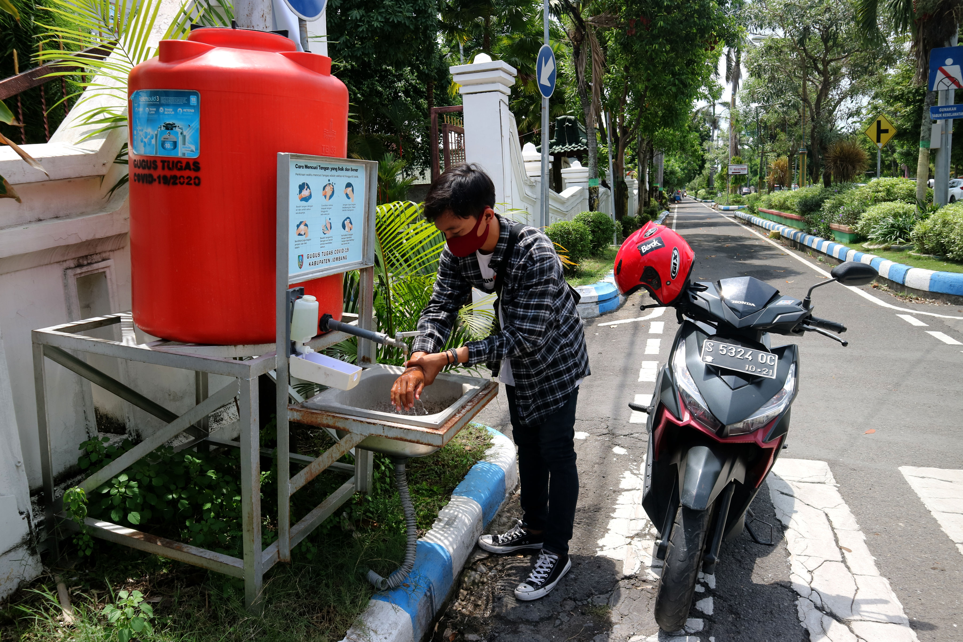 Warga mencuci tangan di wastafel portabel yang ada di Jalan Wahid Hasyim Kabupaten Jombang, Jawa Timur, Selasa (24/11/2020)