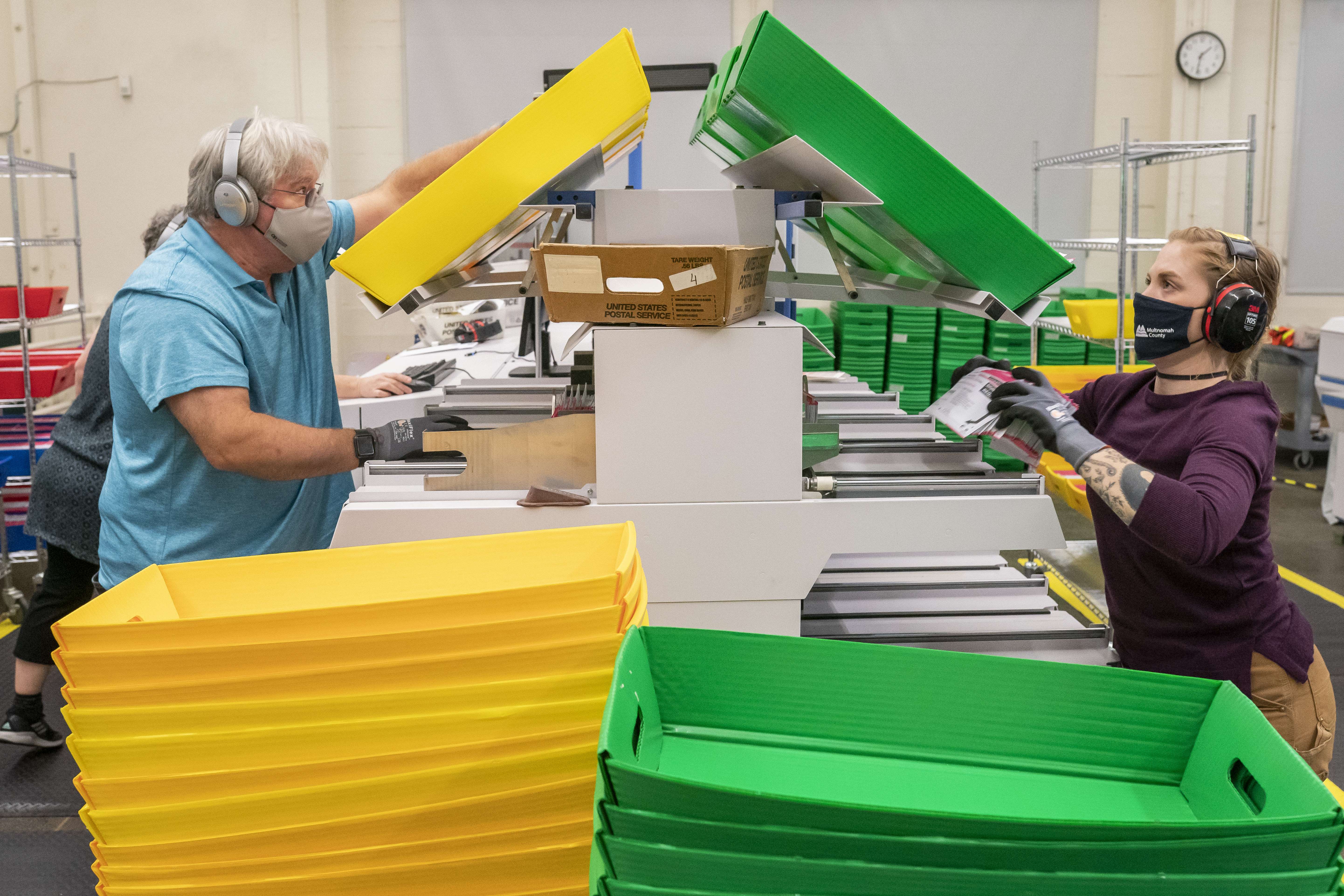 Petugas memilah-milah surat suara yang masuk di kantor KPU Multnomah County, Portland, Oregon.