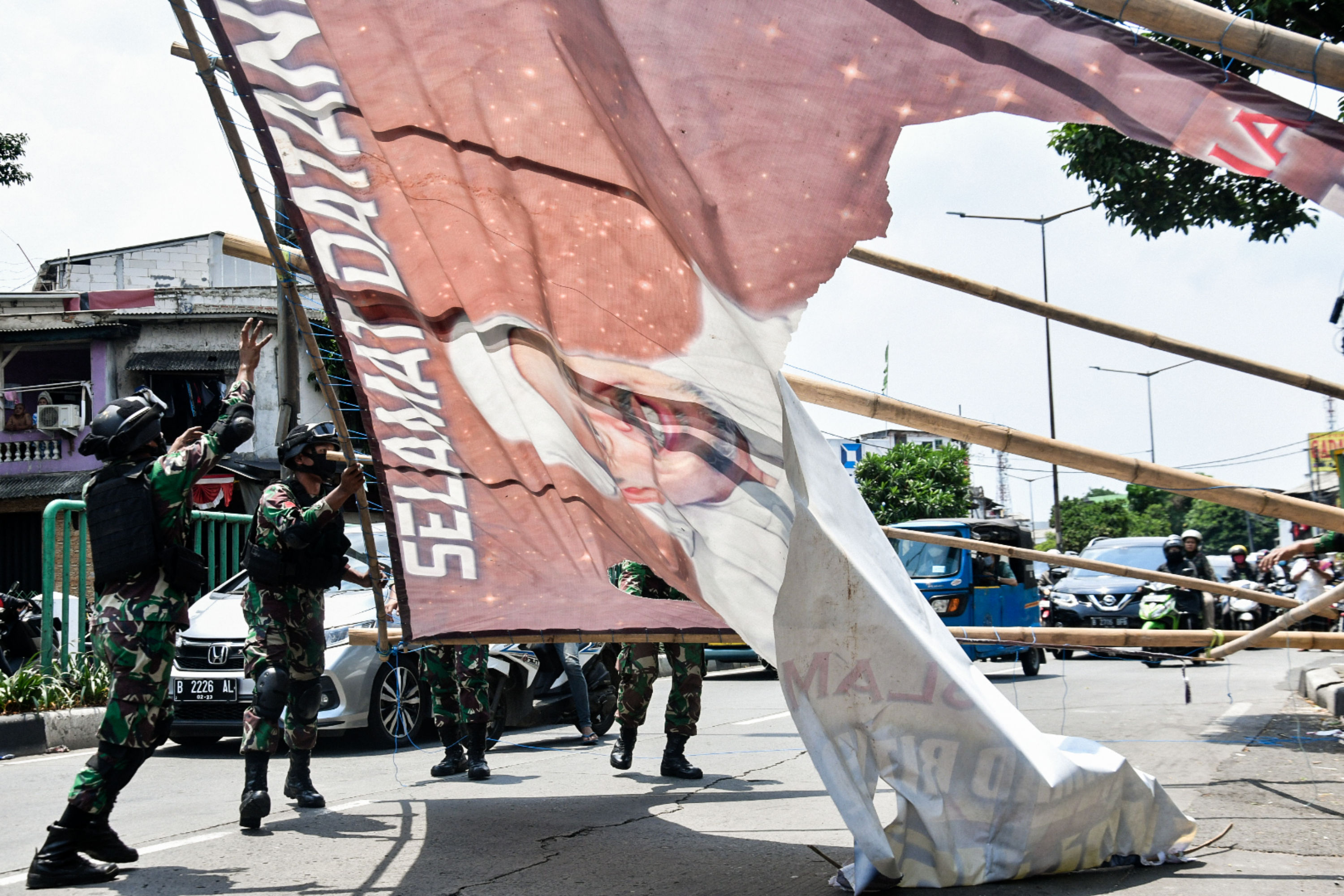 Sejumlah anggota TNI mencopot baliho bergambar wajah pimpinan FPI Rizieq Shihab di kawasan Tanah Abang, Jakarta.