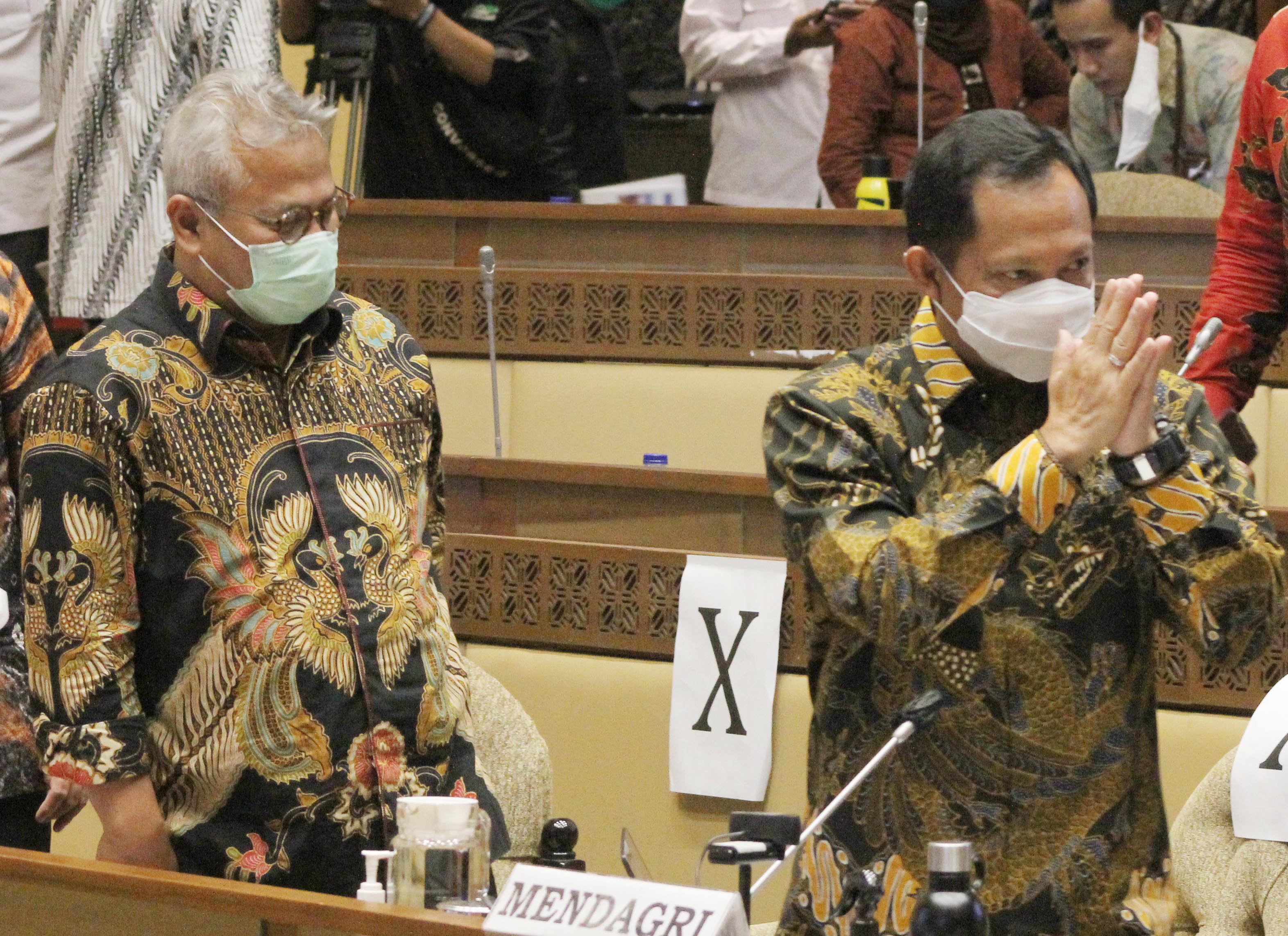 Mendagri Tito Karnavian (kanan) disaksikan Ketua KPU Arief Budiman (kiri) memberi salam sebelum mengikuti rapat kerja dengan Komisi II DPR.