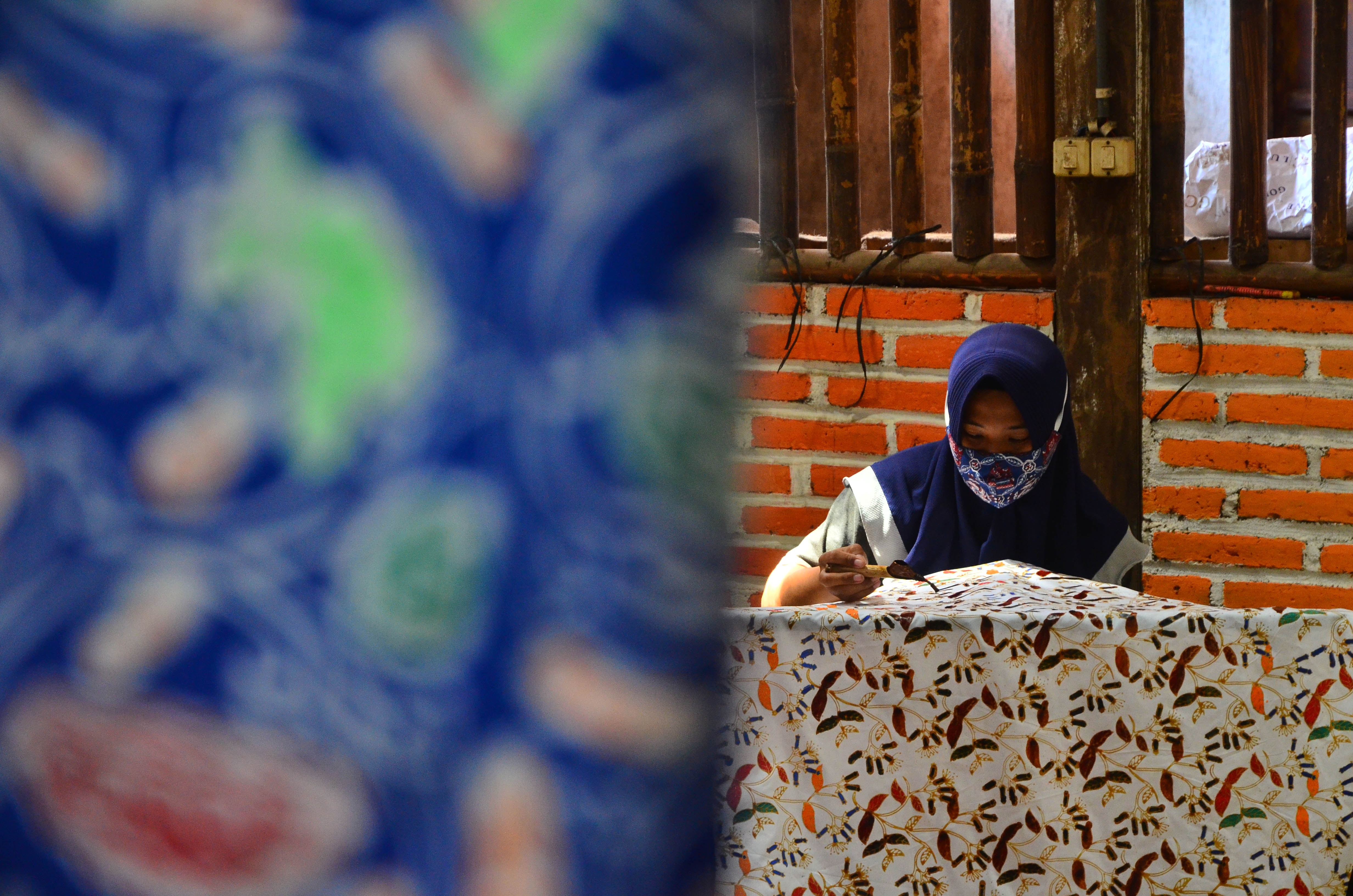 Perajin menyelesaikan pembuatan kain batik di Desa Karangmalang, Gebog, Kudus, Jawa Tengah.
