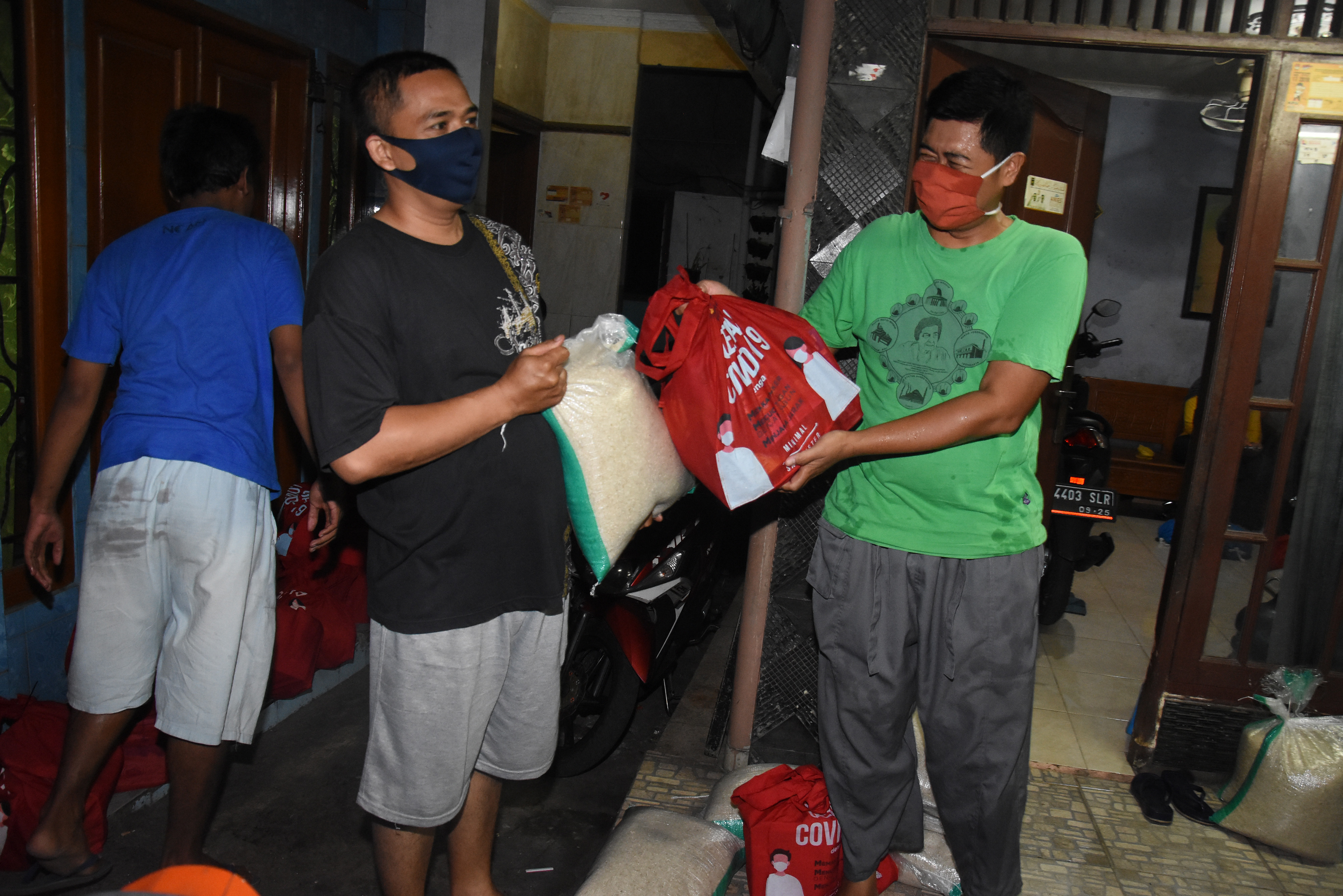 Warga menerima paket bantuan sosial sembako tahap ke-7 dari perwakilan pengurus RT di permukiman Jalan Bangka IV, Kelurahan Pela Mampang
