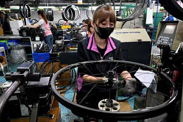 Seorang pekerja mengenakan di sebuah pabrik di Taiwan