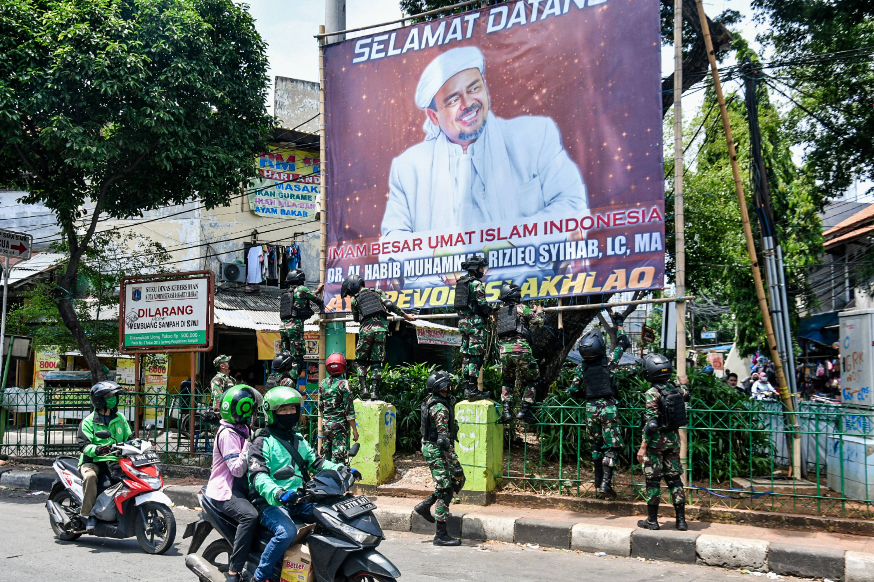 Sejumlah anggota TNI mencopot baliho bergambar wajah pimpinan FPI Rizieq Shihab di kawasan Tanah Abang, Jakarta.