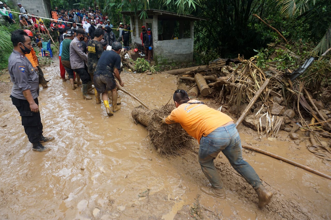 Warga bergotong royong membersihkan pemukiman dari gelondongan kayu, di Kecamatan Bahorok, Langkat, yang dibawa banjir, Rabu (28/11/2020)