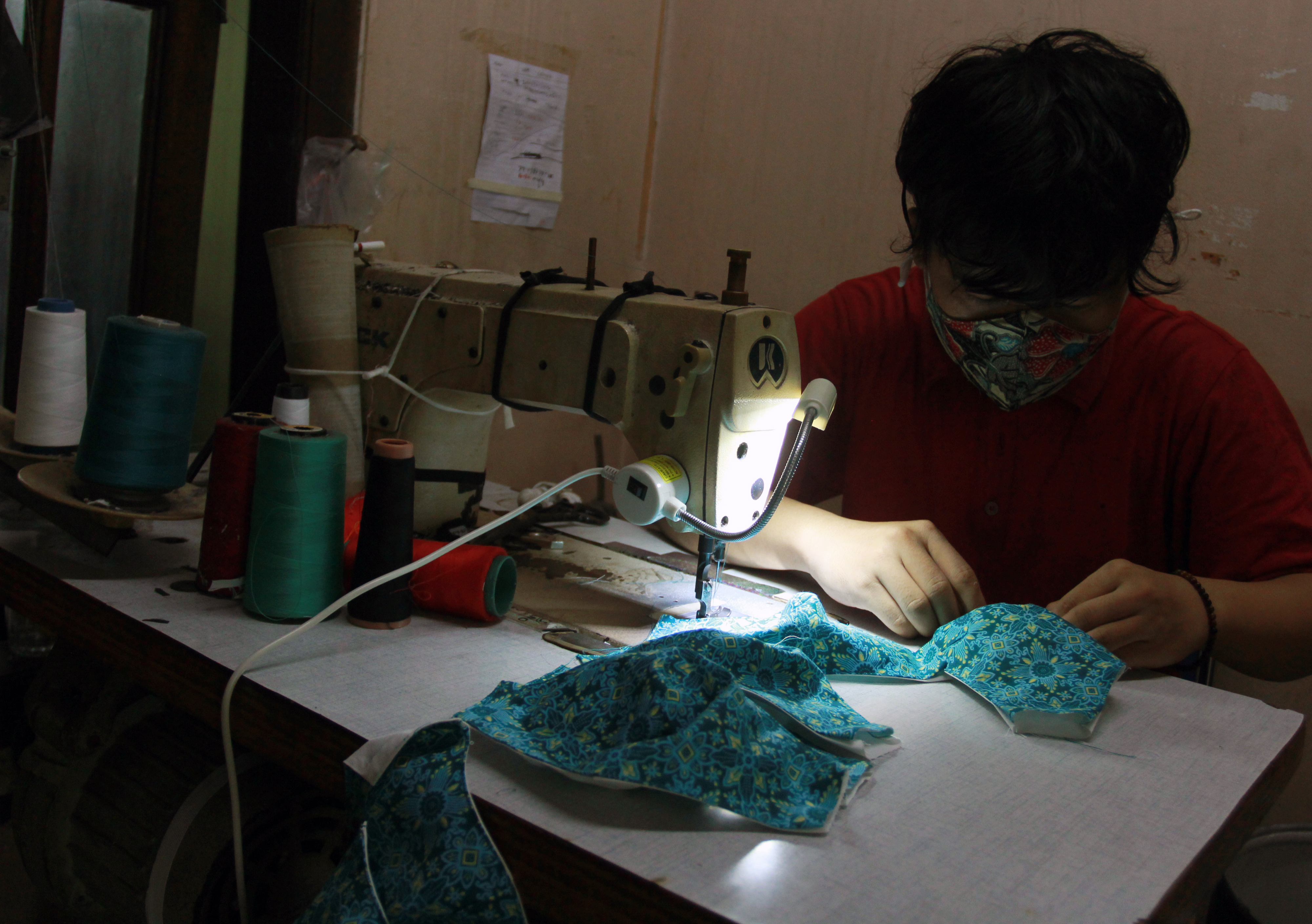 Pekerja menyelesaikan pembuatan masker kain di Pesanggrahan, Jakarta.