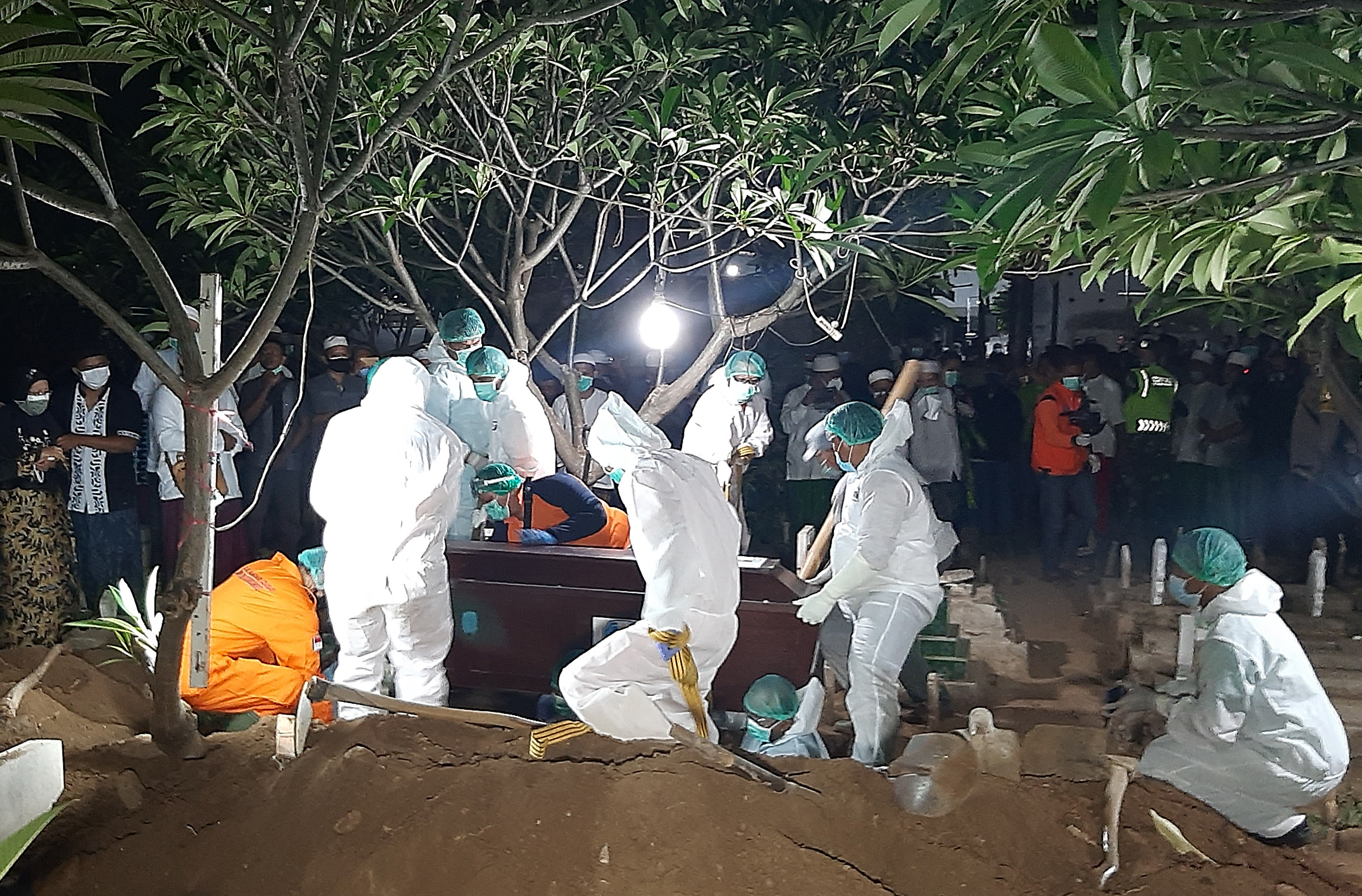 Petugas memakamkan jenazah Bupati Situbondo Dadang Wigiarto di tempat pemakaman umum Patokan, Situbondo, Jawa Timur, kemarin.