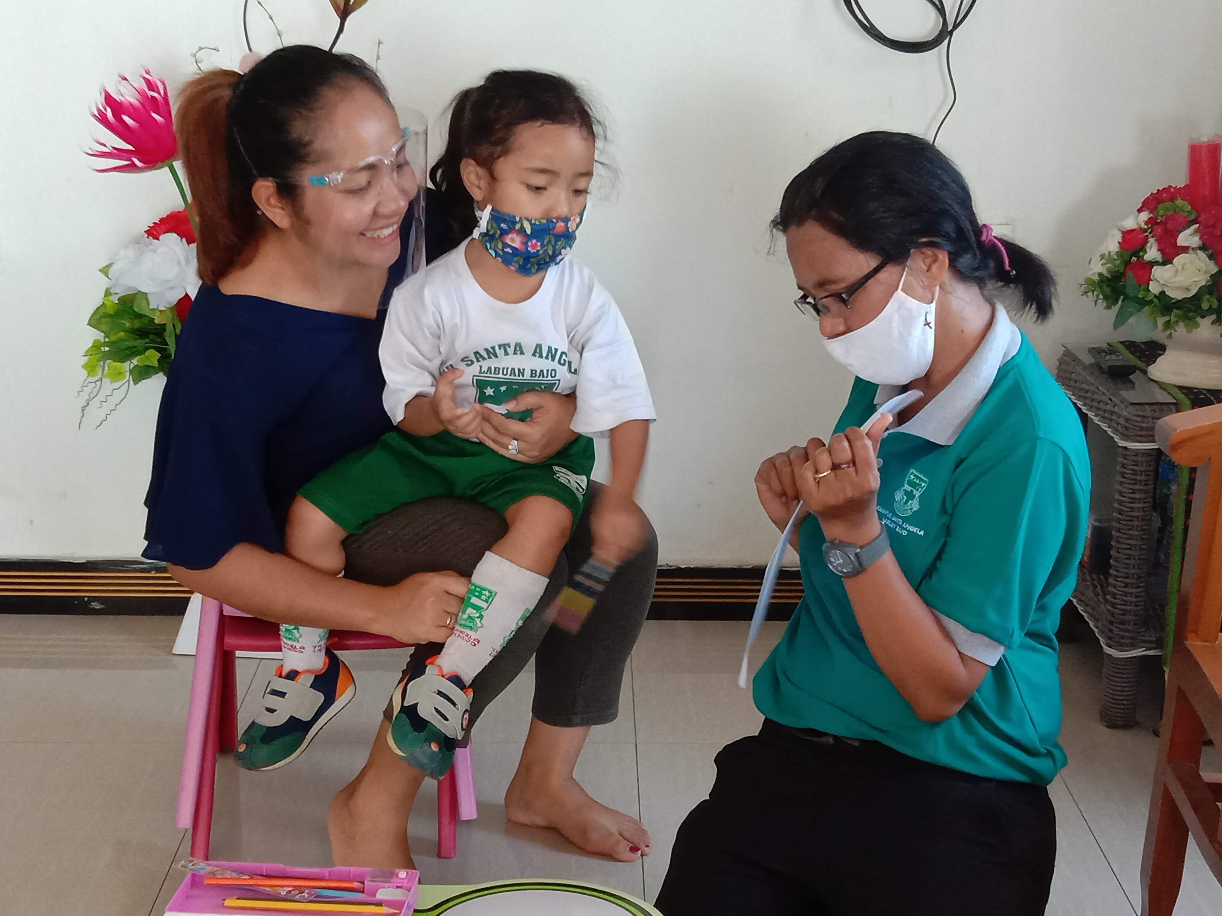Seorang siswa tengah belajar di rumah bersama orangtua dan pembimbing. 