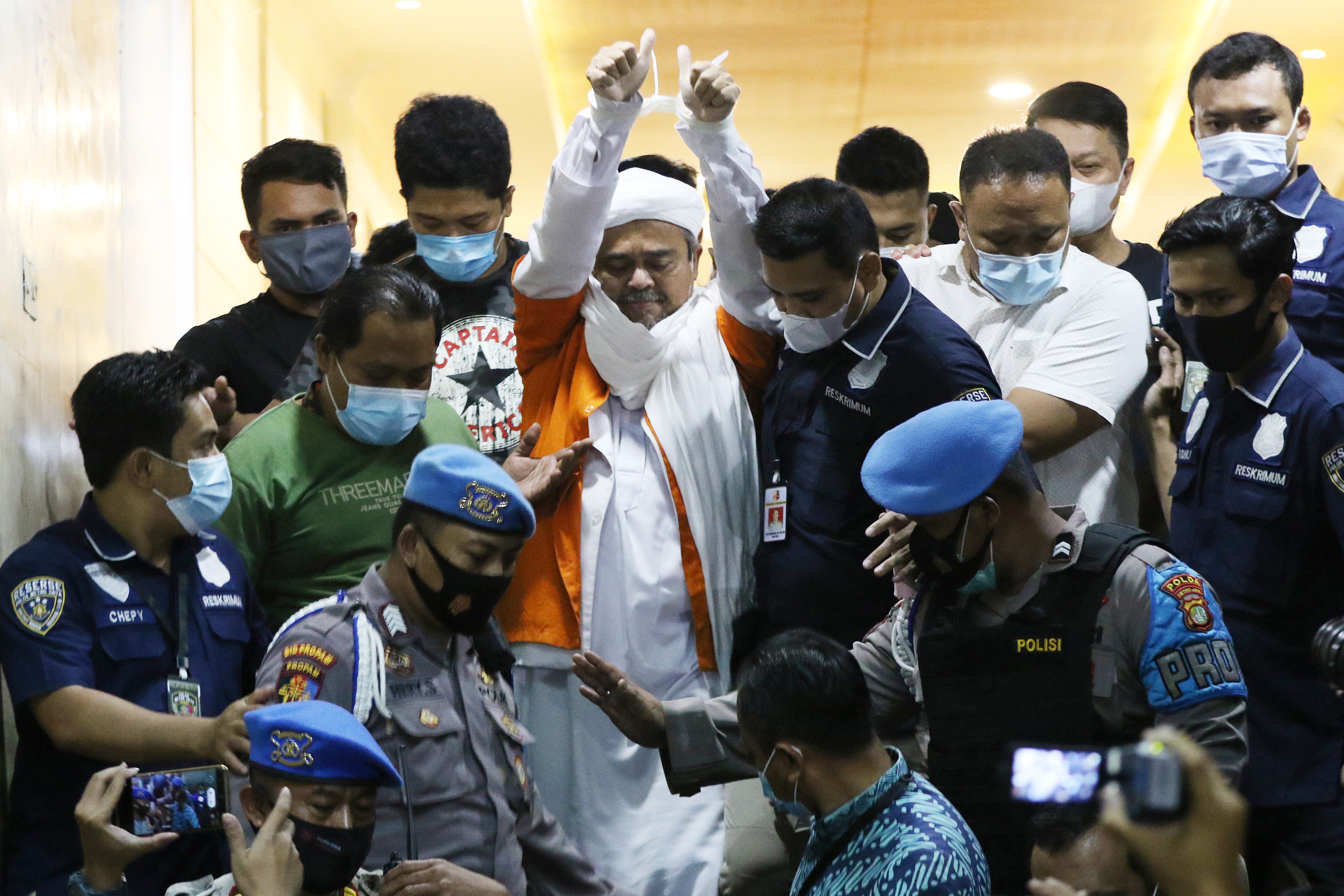 Pimpinan FPI Rizieq Shihab berjalan menuju mobil tahanan usai diperiksa di Mapolda Metro Jaya, beberapa waktu lalu.