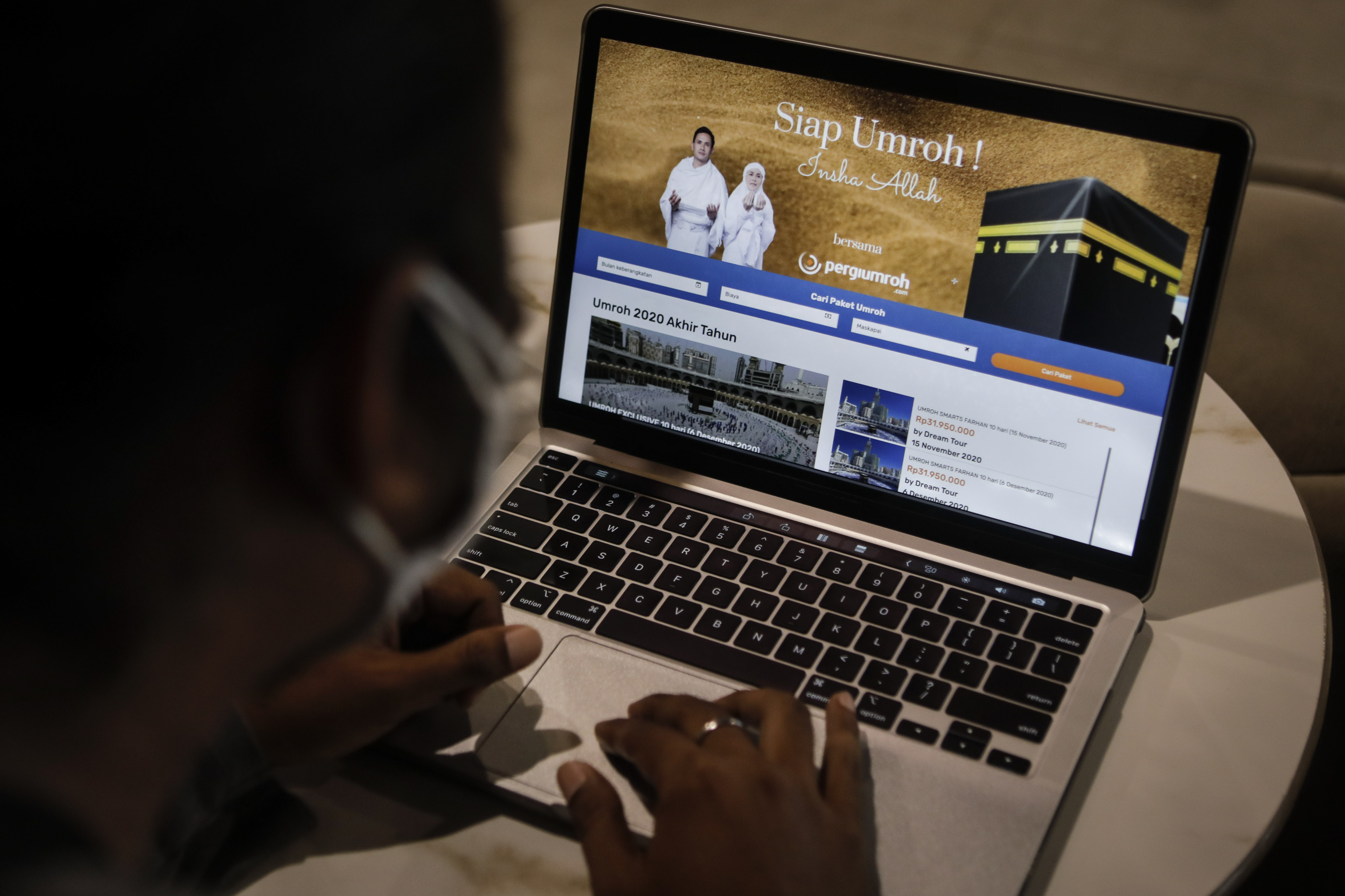 Warga mengamati informasi paket keberangkatan umrah secara daring di Jakarta, Kamis (5/11).