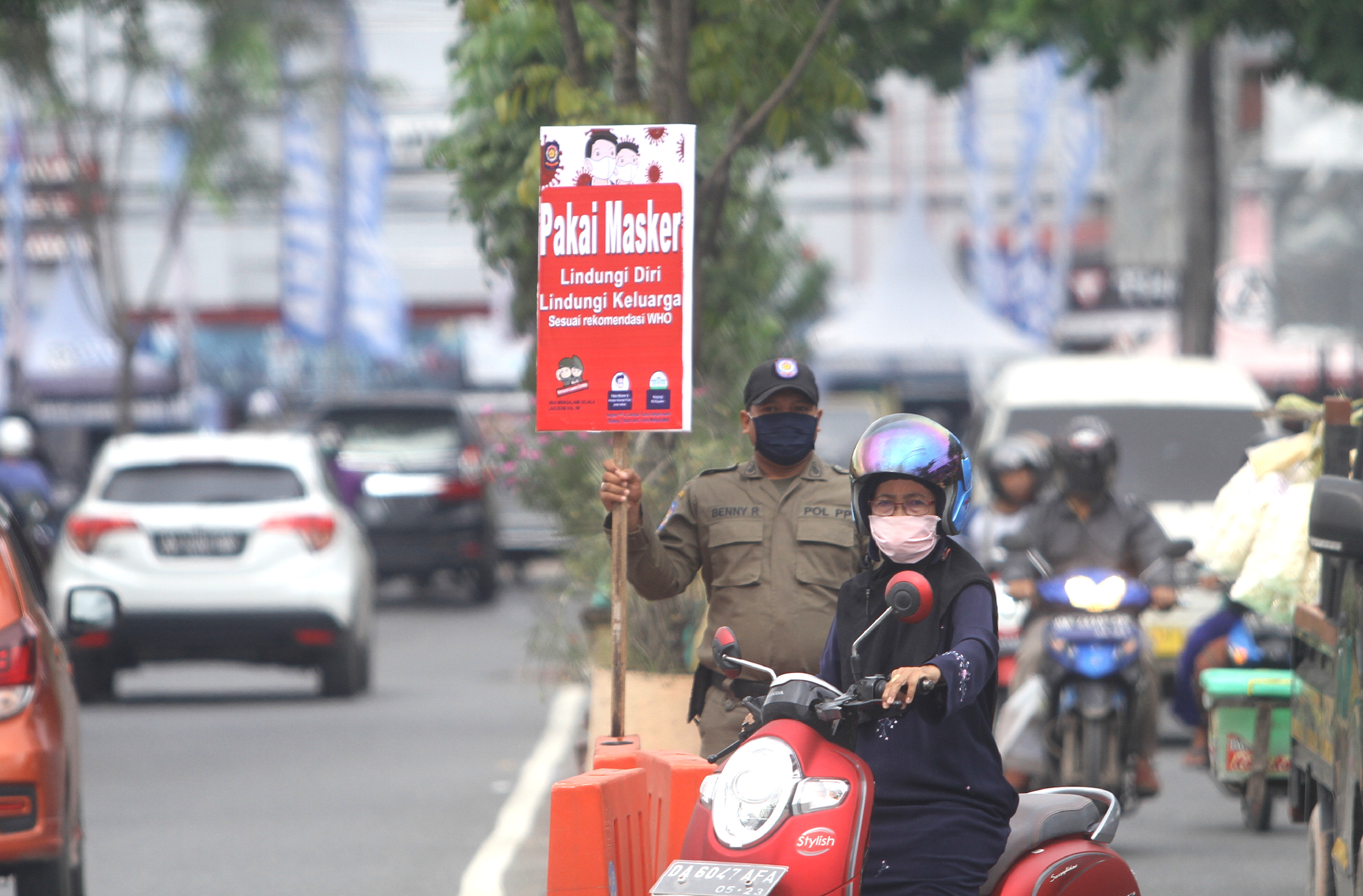 Petugas Satpol PP Banjarmasin membawa poster imbauan penggunakaan masker di jalan Ahmad Yani, Banjarmasin, Kalimantan Selatan.