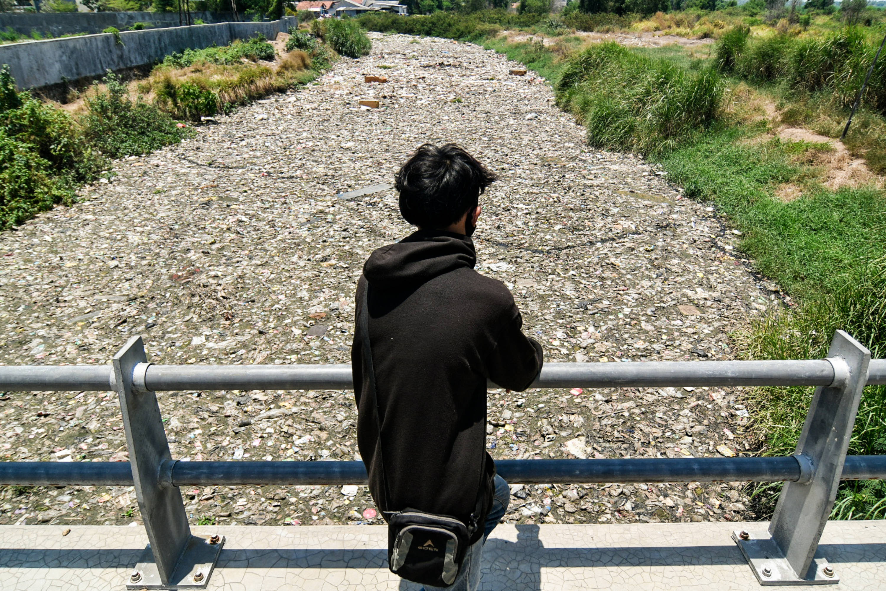 Warga melihat sampah yang menumpuk di aliran kali Kampung Bogor, Desa Setiasih, Tarumajaya, Kabupaten Bekasi, Rabu (30/9/2020).