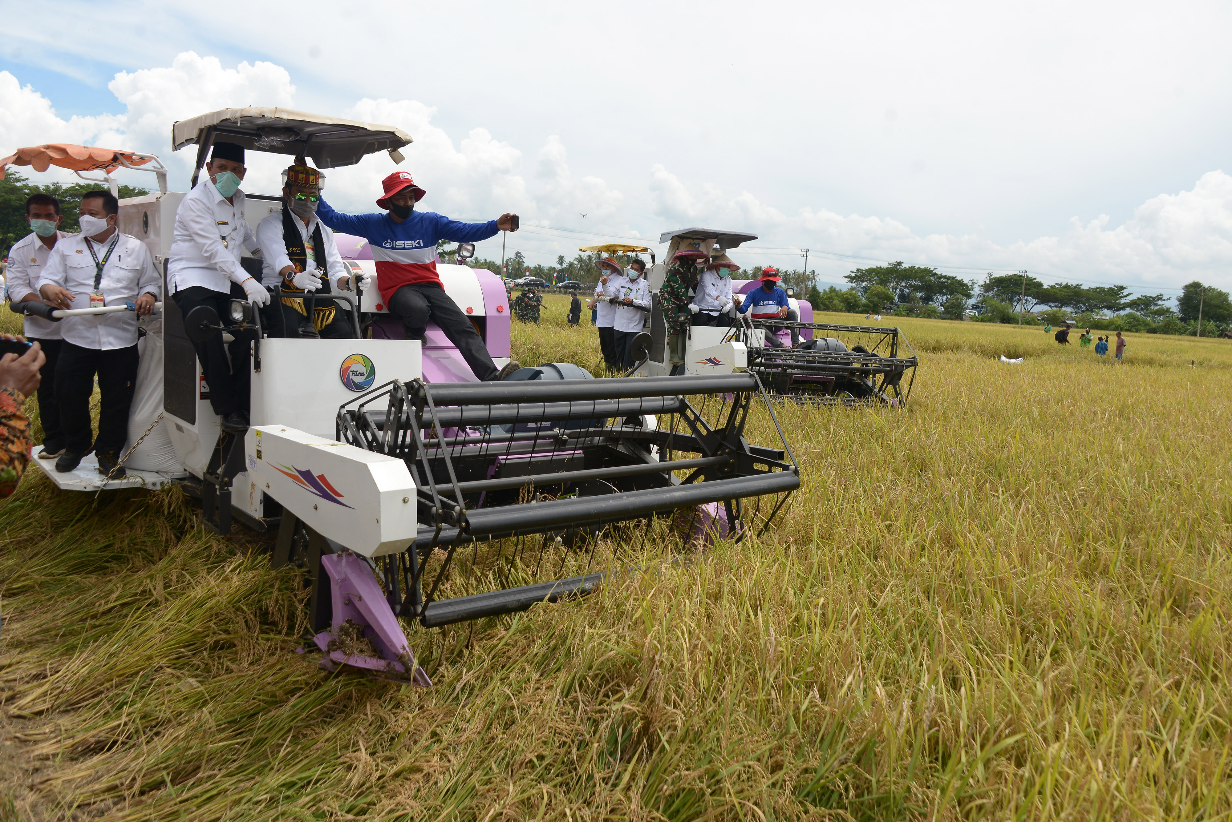  Menteri Pertanian, Syahrul Yasin Limpo (tengah) didampingi Bupati Aceh Besar, Mawardi Ali (kiri) mengoperasikan mesin pemotong padi saat pa