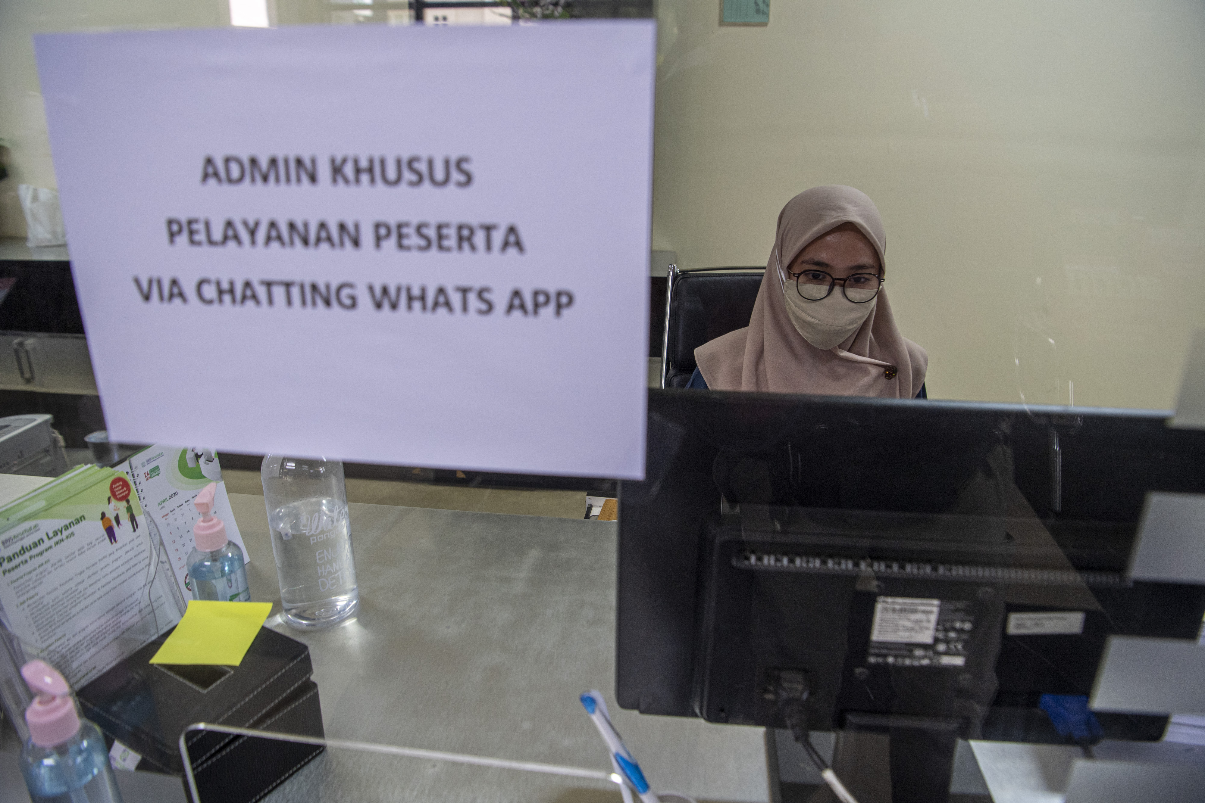 Petugas melayani peserta BPJS Kesehatan tanpa tatap muka di Kantor BPJS Kesehatan kantor cabang Palembang, Sumatera Selatan, Kamis (8/10).