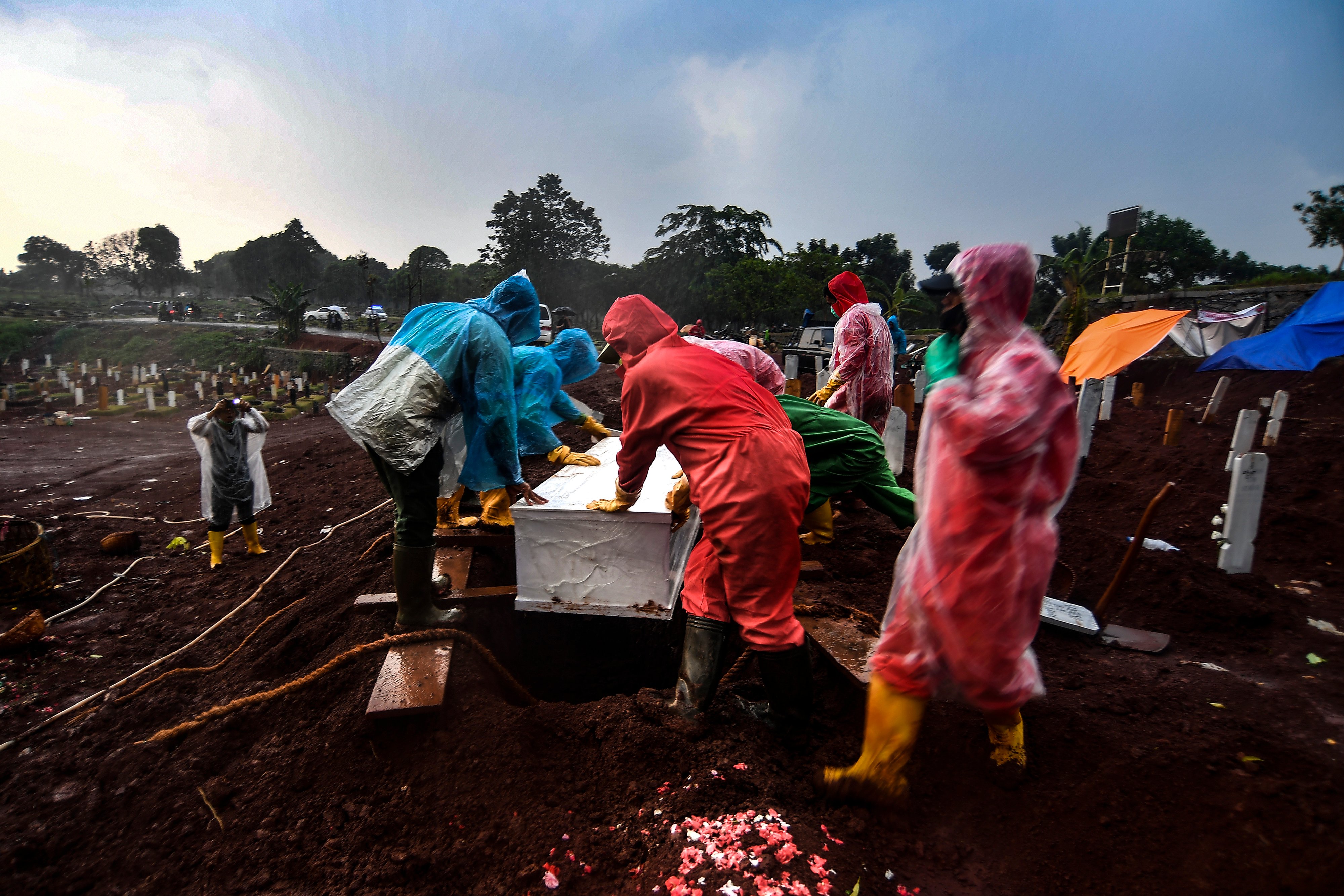 Ilustrasi/Petugas pemakaman memasukan jenazah ke dalam lubang di lokasi pemakaman COVID-19 TPU Pondok Ranggon, Jakarta, Jumat (2/10)