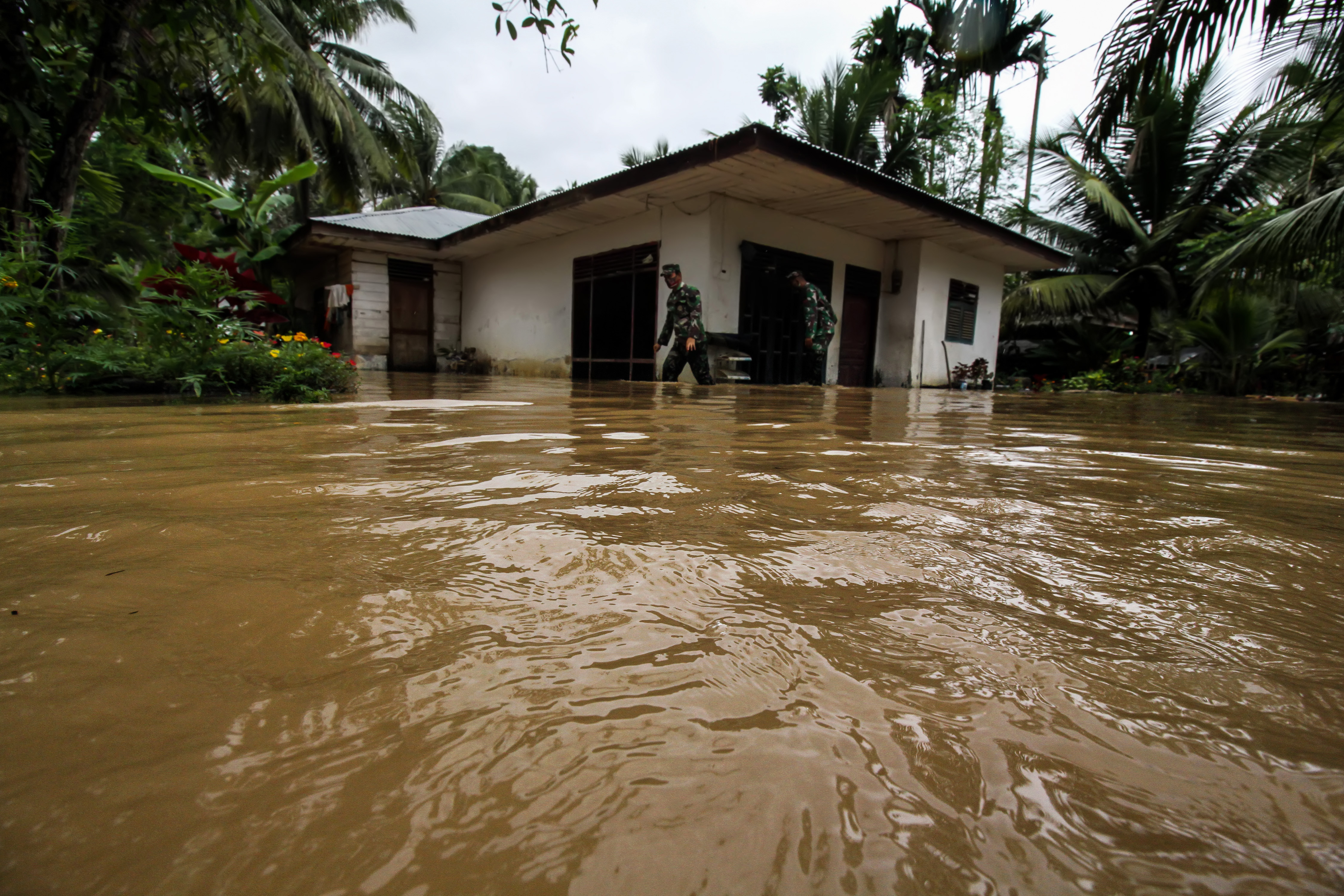Babinsa TNI Kodim 0103 Aceh Utara mengecek rumah warga saat terjadi banjir di Desa Hasan Kareung, Blang Mangat, Lhokseumawe, Sabtu (5/12)
