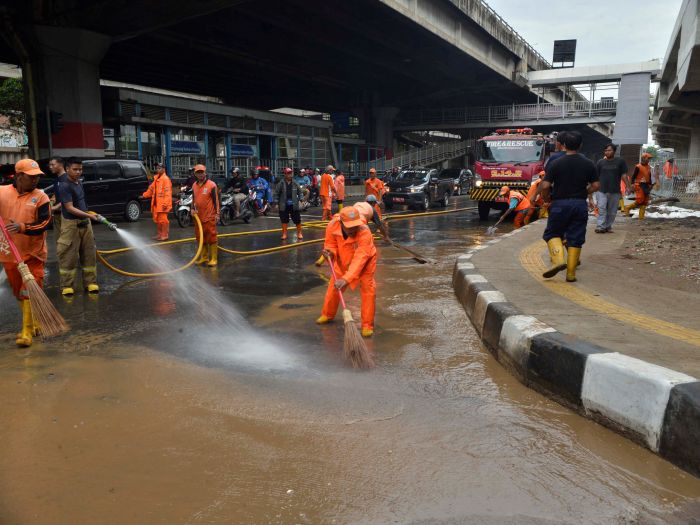 Pasukan oranye membersihkan ruas jalan di Jakarta.