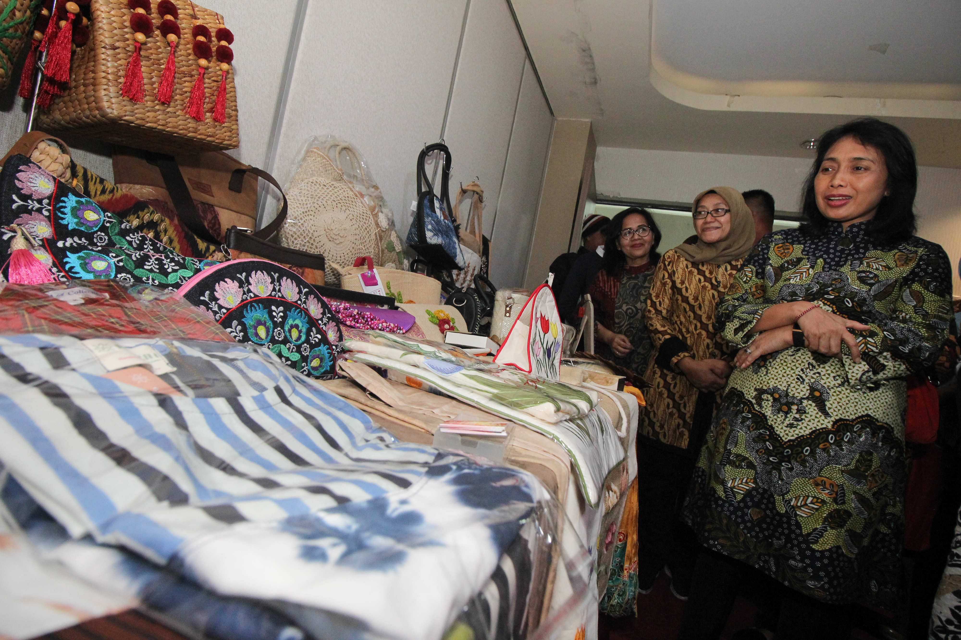 Menteri PPPA I Gusti Ayu Bintang Darmawati (kanan) mengamati kerajinan buatan UKM saat berkunjung di Surabaya, Jawa Timur, Minggu (8/12).